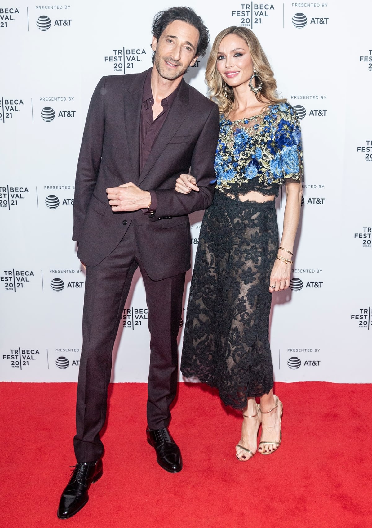 Adrien Brody and Georgina Chapman made their red carpet debut as a couple at the Clean premiere during the Tribeca Film Festival on June 19, 2021, with Chapman stunning in a floral-embroidered sheer lace dress paired with gold platform heels