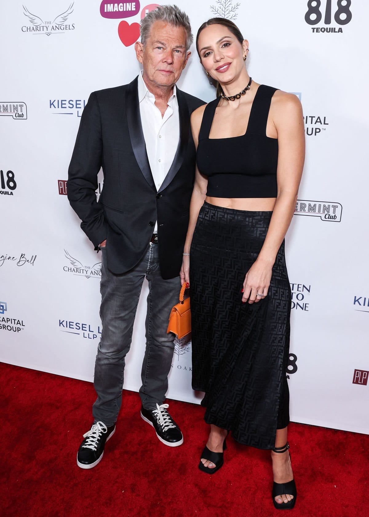 Katharine McPhee adds height in black square-toe platform sandals, pairing them with a cropped black top and Fendi monogram skirt alongside husband David Foster