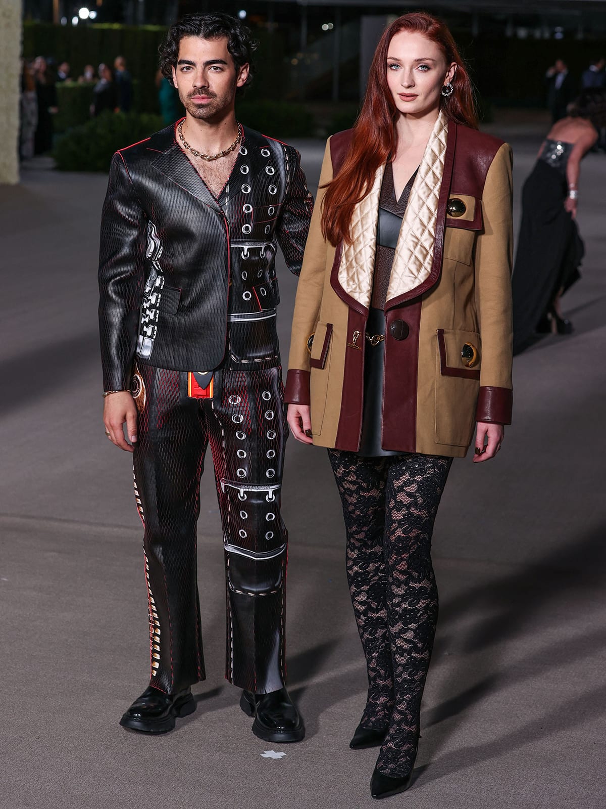 Joe Jonas complements Sophie Turner’s edgy Louis Vuitton look in a coordinated printed ensemble, bringing a sharp, fashion-forward twist to their red-carpet appearance