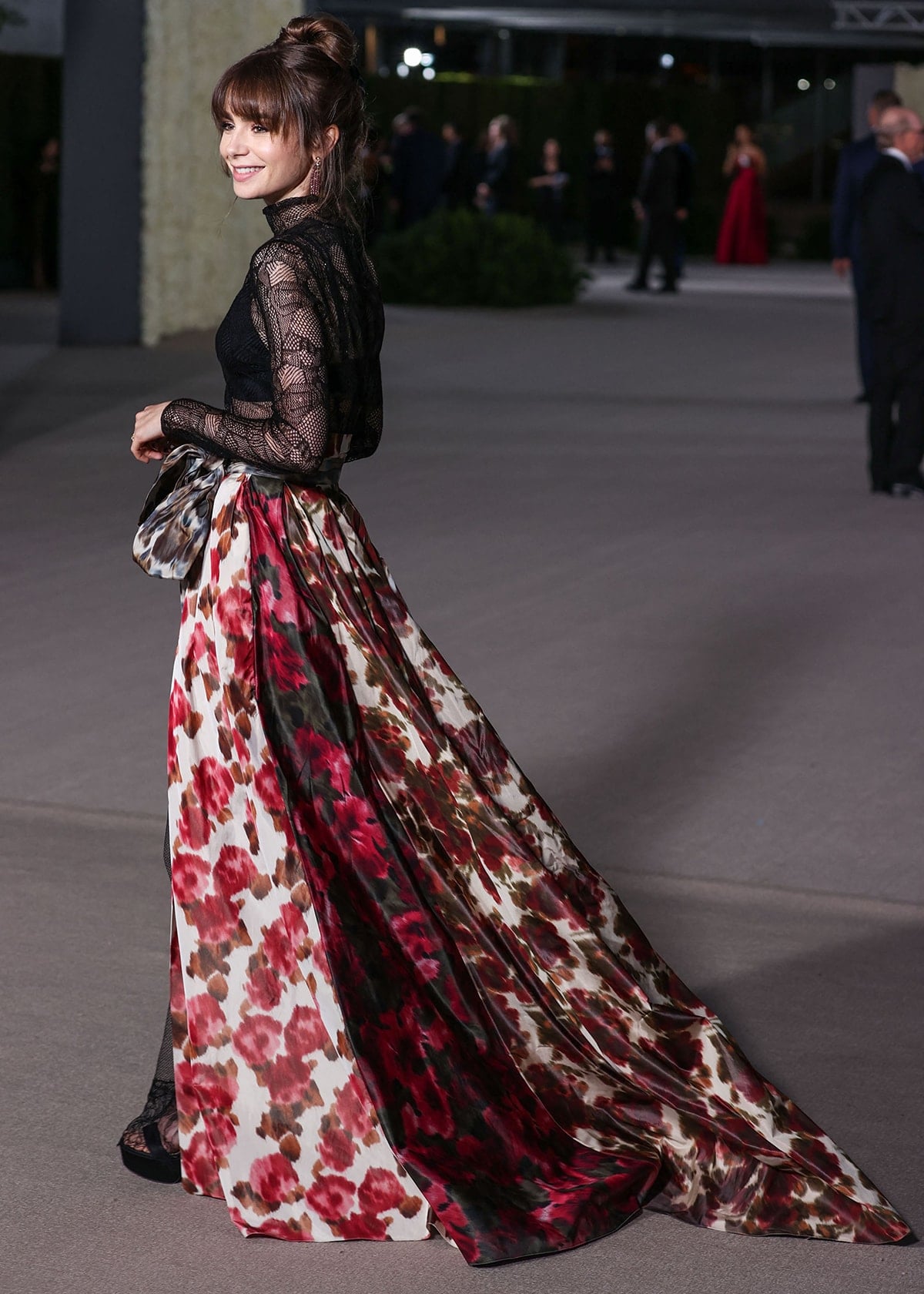 Lily Collins balances romance and edge by pairing her flowing floral Dior skirt with a fitted black technical silk lace top for a modern couture contrast