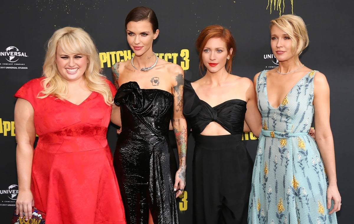 Rebel Wilson, Ruby Rose, Brittany Snow, and Anna Camp bring bold contrasts and coordinated glamour to the Pitch Perfect 3 premiere—Rebel stuns in red, Ruby goes edgy in black sequins, Brittany opts for a sleek cutout jumpsuit, and Anna glows in a floral-embroidered pastel gown