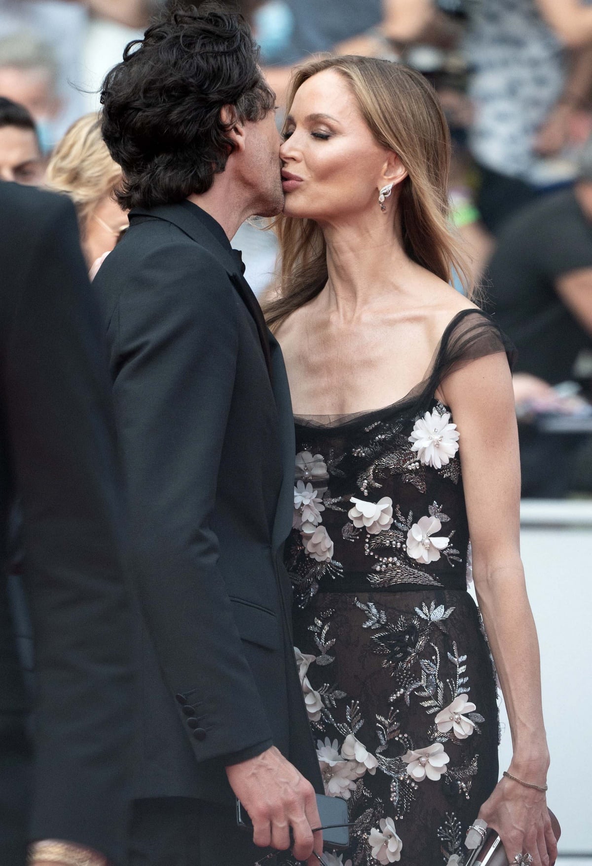 Adrien Brody and Georgina Chapman share a rare public kiss at The French Dispatch premiere during the 74th Cannes Film Festival on July 12, 2021, with Chapman turning heads in a sheer black floral-embellished gown adorned with delicate 3D appliqués