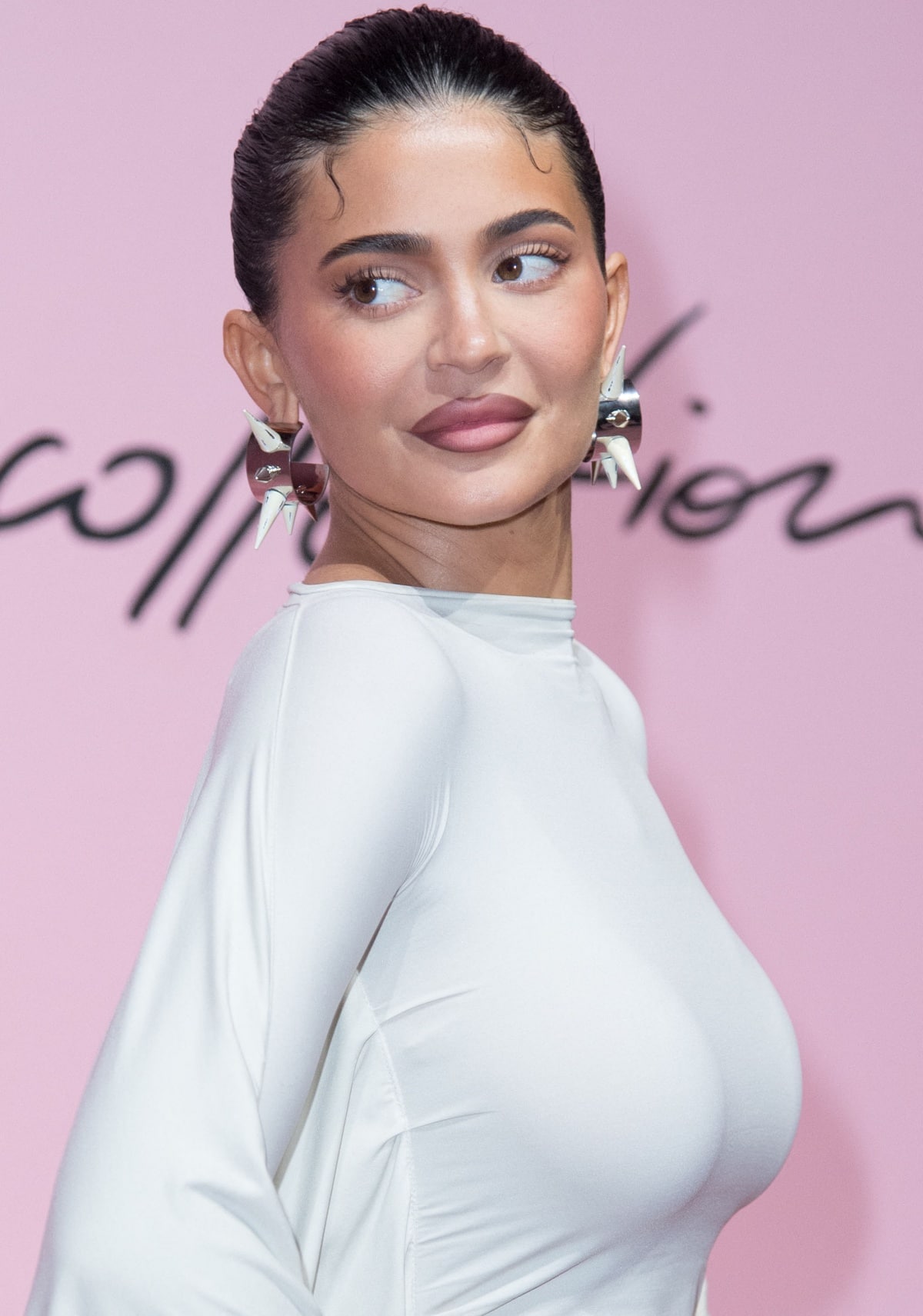 Kylie Jenner with a sleek updo and Off-White spiked earrings at the Acne Studios Spring 2023 runway presentation
