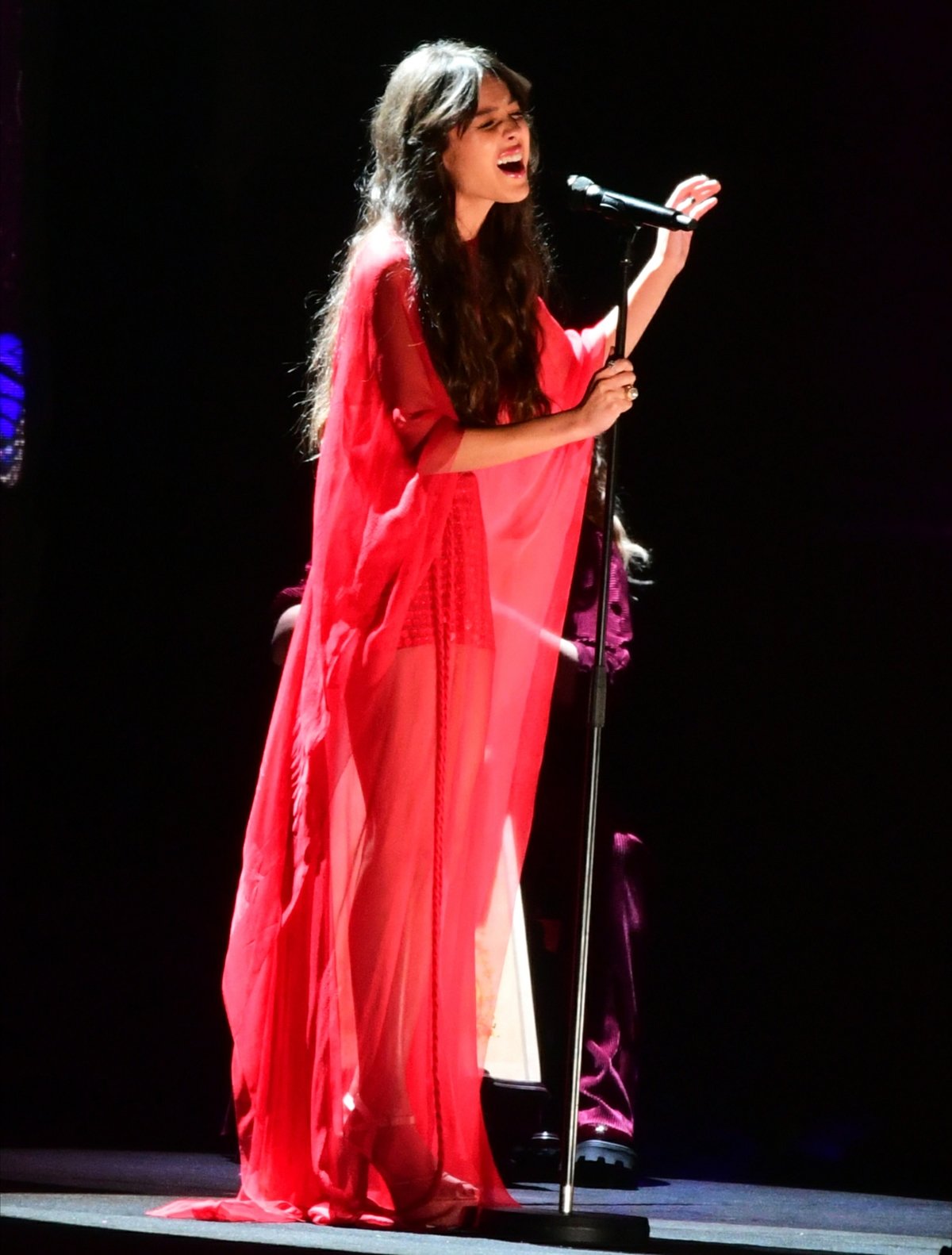 Olivia Rodrigo performs “Drivers License” at the BRIT Awards 2021 at The O2 Arena in London on May 11, 2021, wearing a sheer, flowing red gown layered over a fitted mini, its ethereal drape amplifying the emotion of the performance as she commands the stage