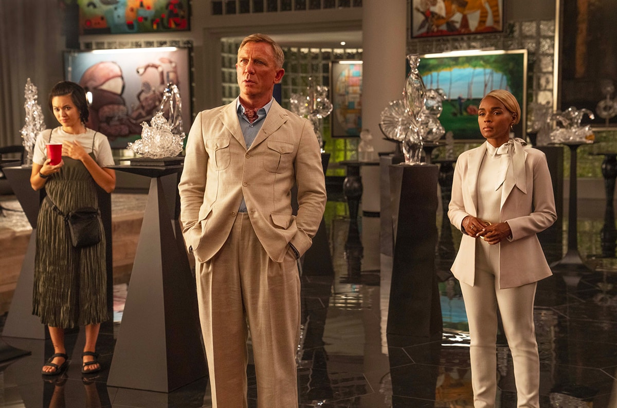 Daniel Craig and Janelle Monáe share a scene in Glass Onion: A Knives Out Mystery, standing in a luxurious art-filled room