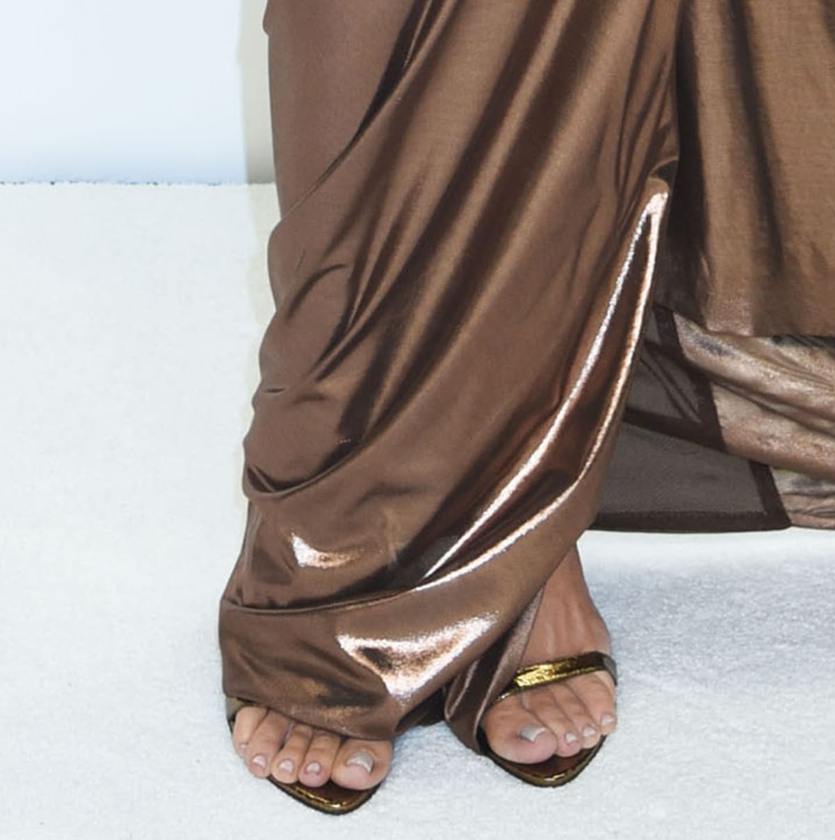 Khloé Kardashian shows off her pedicured feet in gold Tom Ford heels