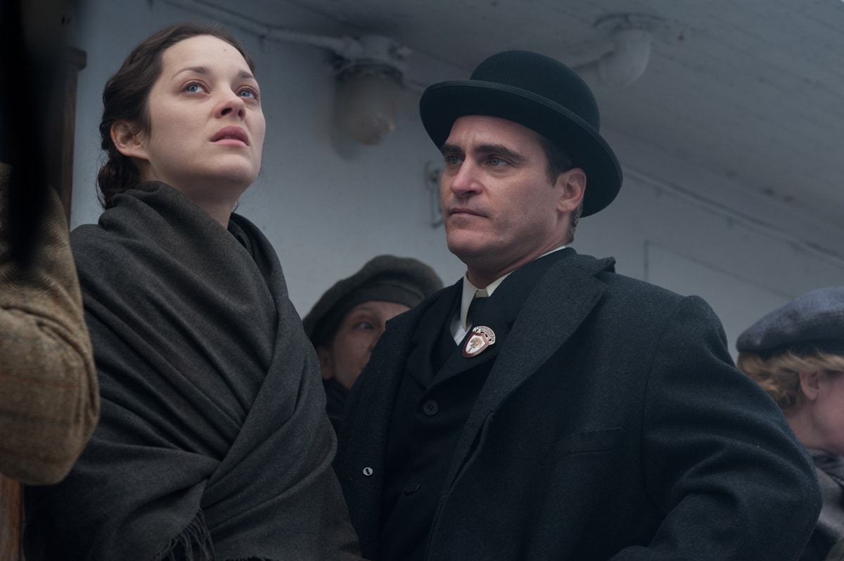 Marion Cotillard as Ewa Cybulska and Joaquin Phoenix as Bruno Weiss in The Immigrant, wrapped in period-accurate wool layers during the film’s tense arrival scene
