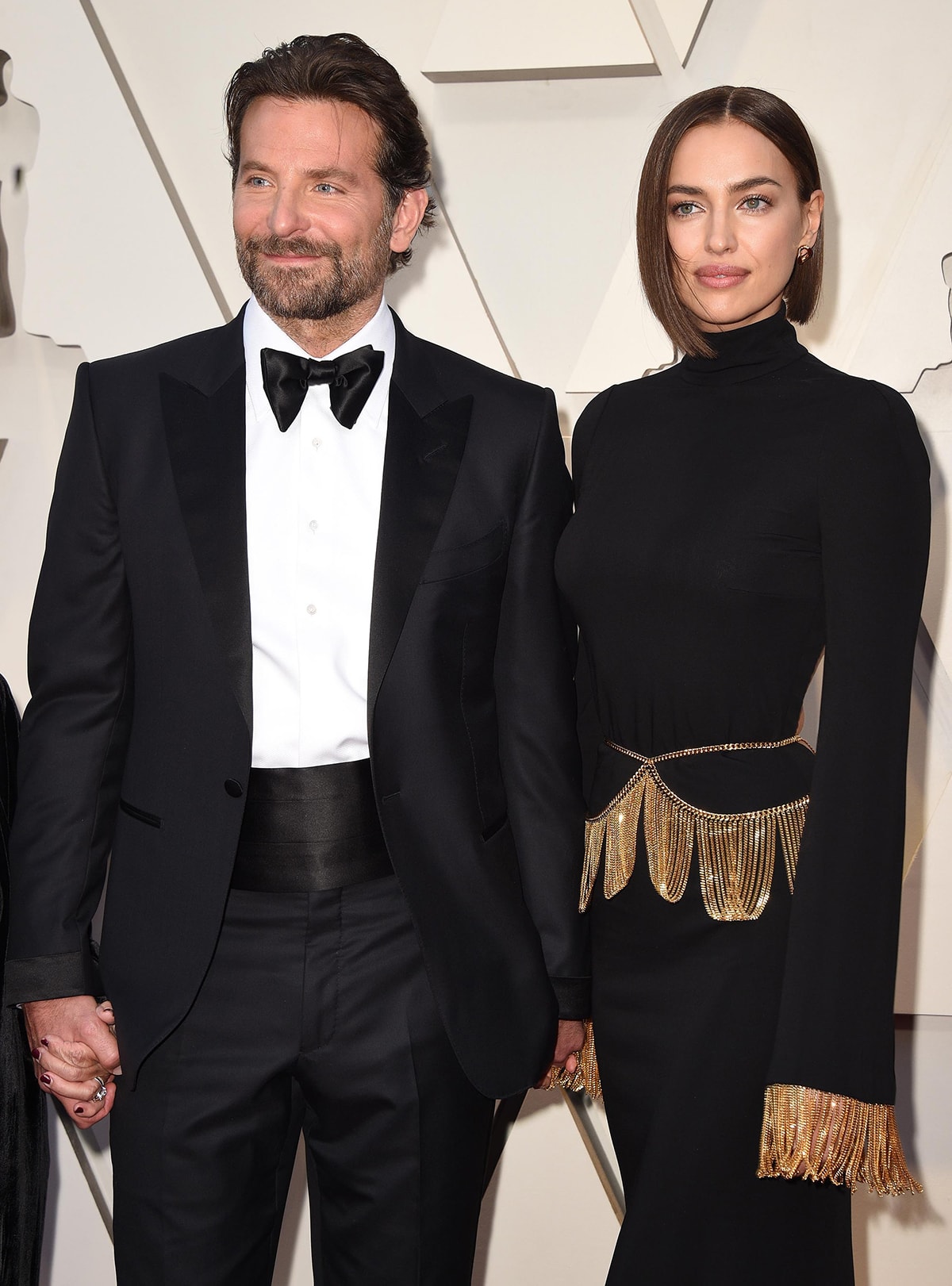 Bradley Cooper and Irina Shayk made a striking pair in coordinated black eveningwear, with her sleek, gold-accented gown adding a touch of glamour to his classic tuxedo