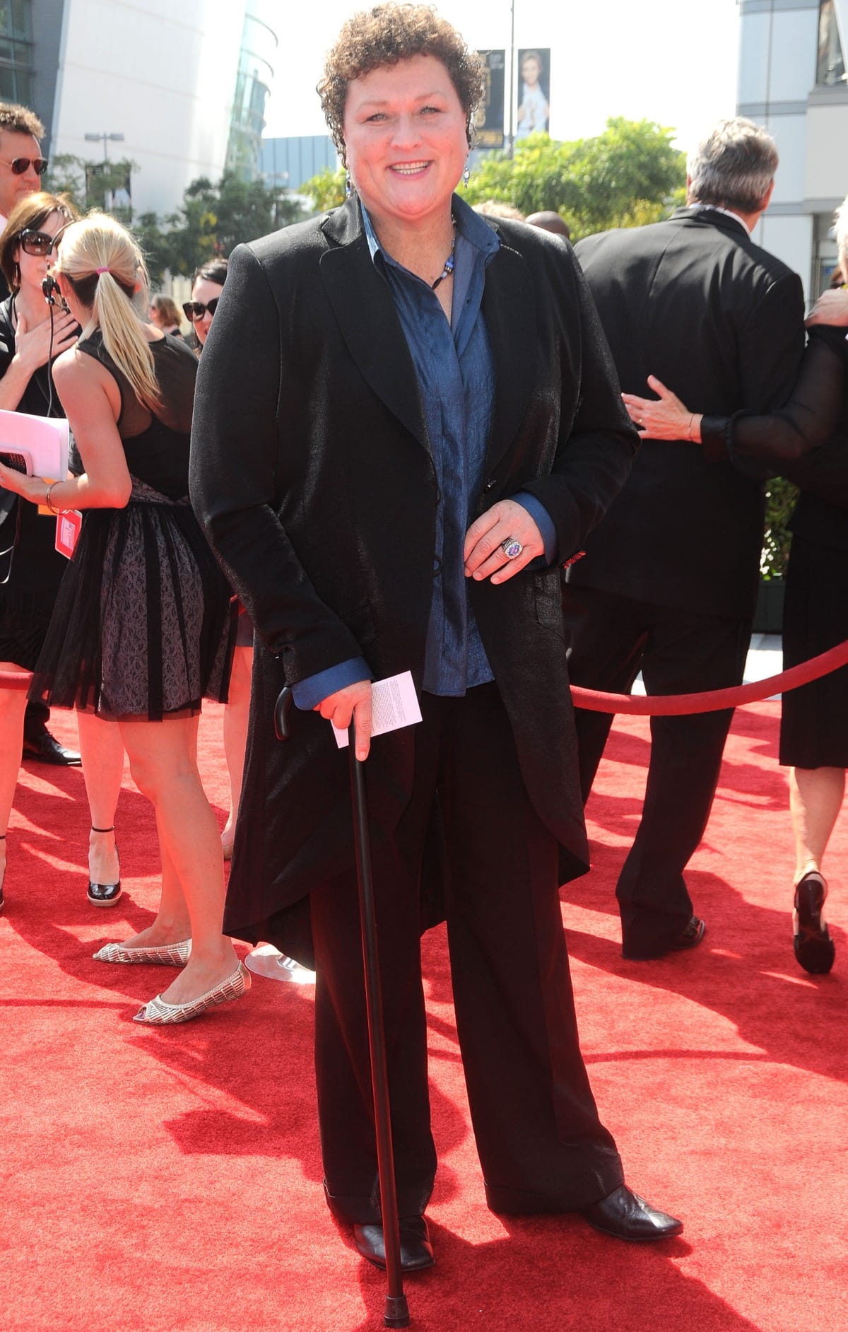 Dot-Marie Jones exuded confidence in a textured black coat, wide-leg trousers, sleek leather shoes, and a blue satin blouse at the 2011 Creative Arts Emmy Awards held in Los Angeles