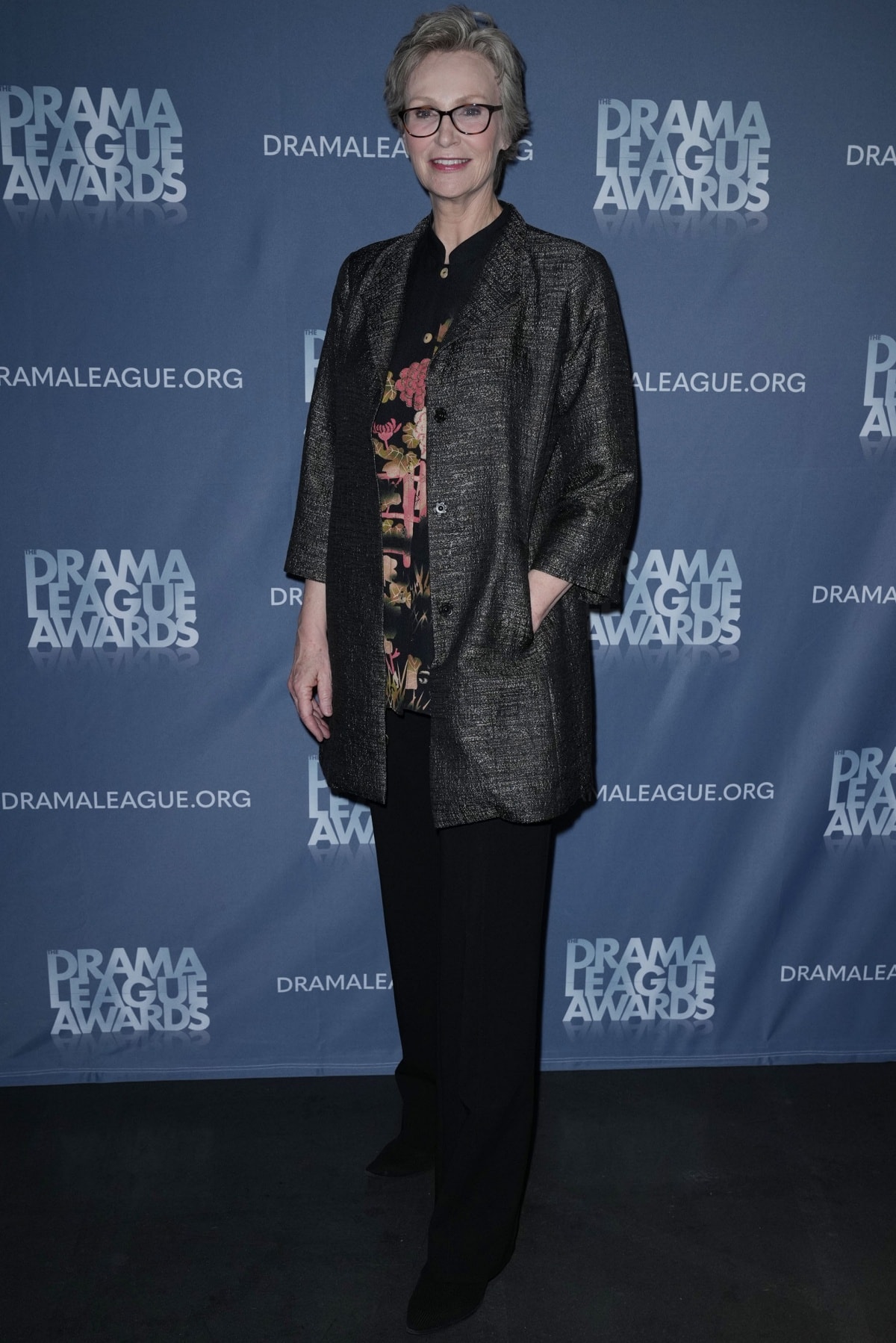 Jane Lynch embraced classic theatrical style in a metallic jacket layered over a floral blouse with black trousers and pointed-toe shoes at the 2022 Drama League Awards in New York on May 20, 2022