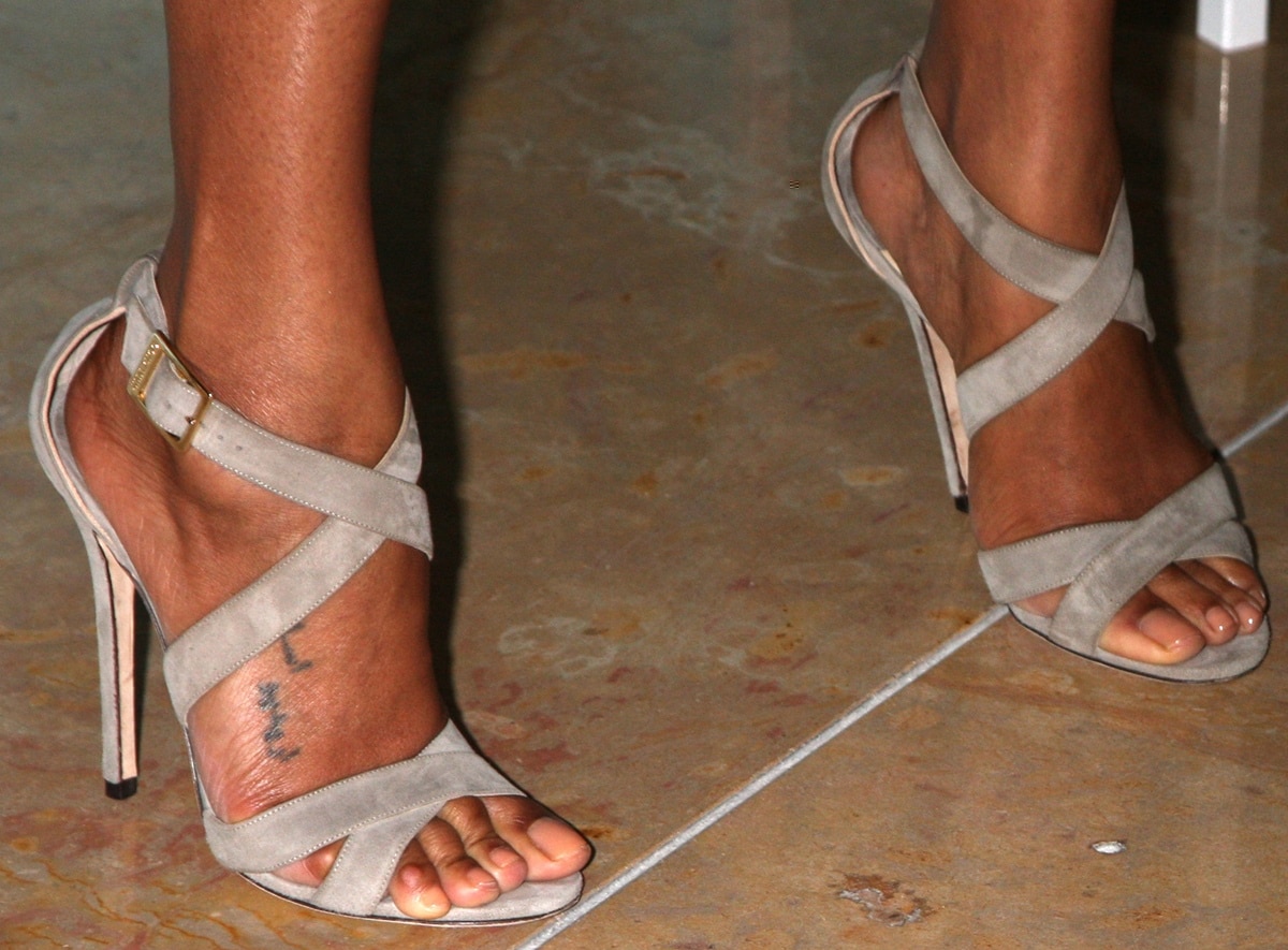 Zoe Saldaña highlights her foot tattoo in soft suede Jimmy Choo crossover sandals, a refined neutral style that elongates her legs with its slim stiletto heel