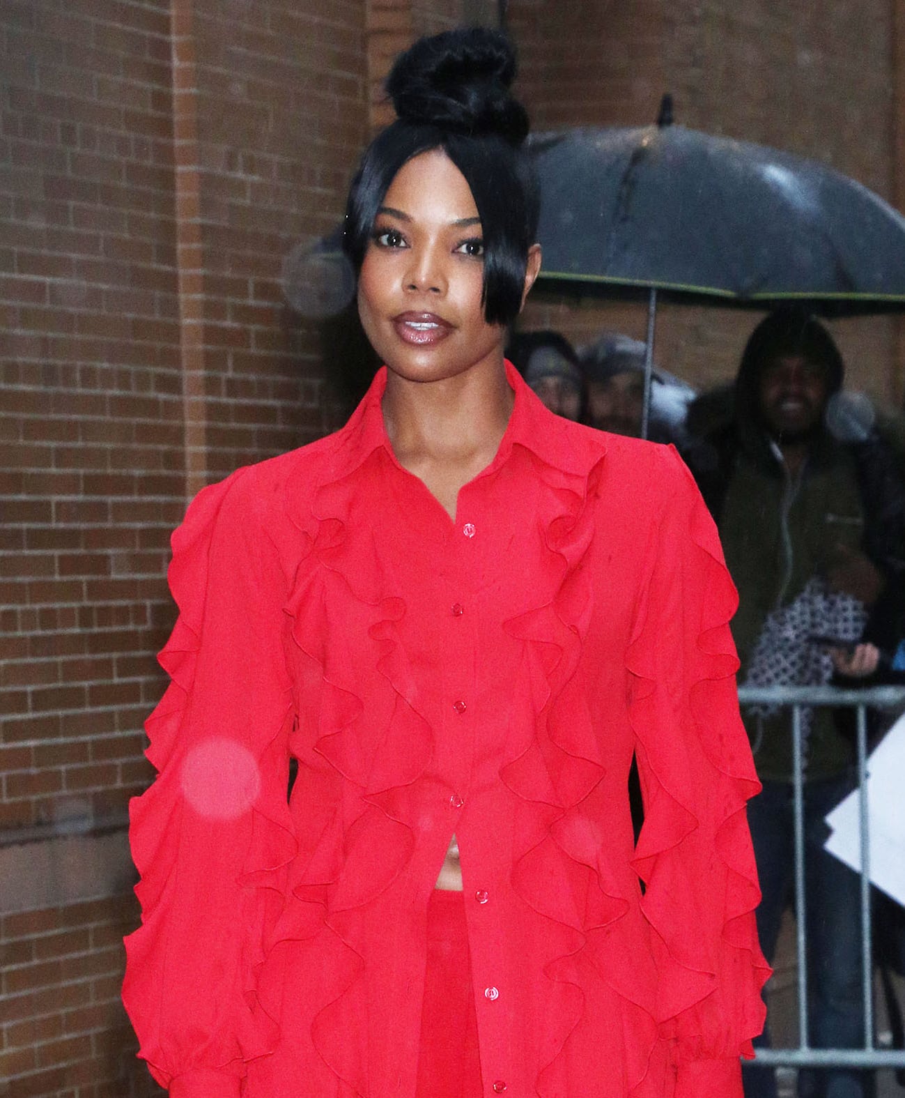 Gabrielle Union wears a top knot with face-framing fringes and highlights her features with smoky eyeshadow