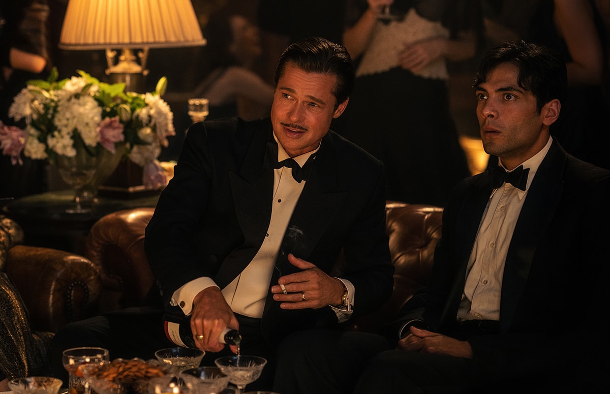 Brad Pitt and Diego Calva share a moment in Babylon, dressed in sharp black-tie tuxedos that capture the film’s opulent Old Hollywood aesthetic