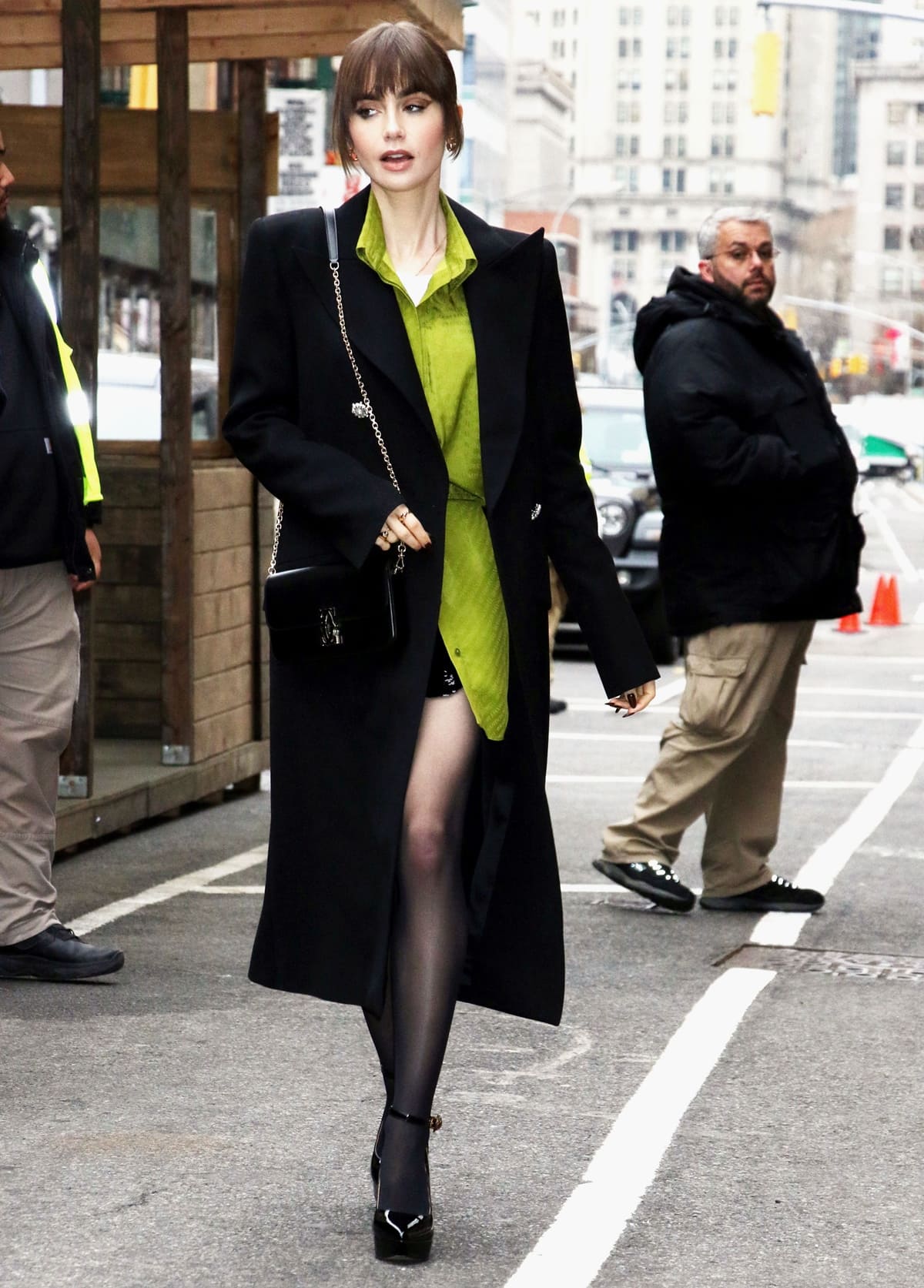 Lily Collins flaunts her legs in a Brandon Maxwell shirt dress styled with a sequined mini skirt, Kurt Geiger Shoreditch pumps and stockings