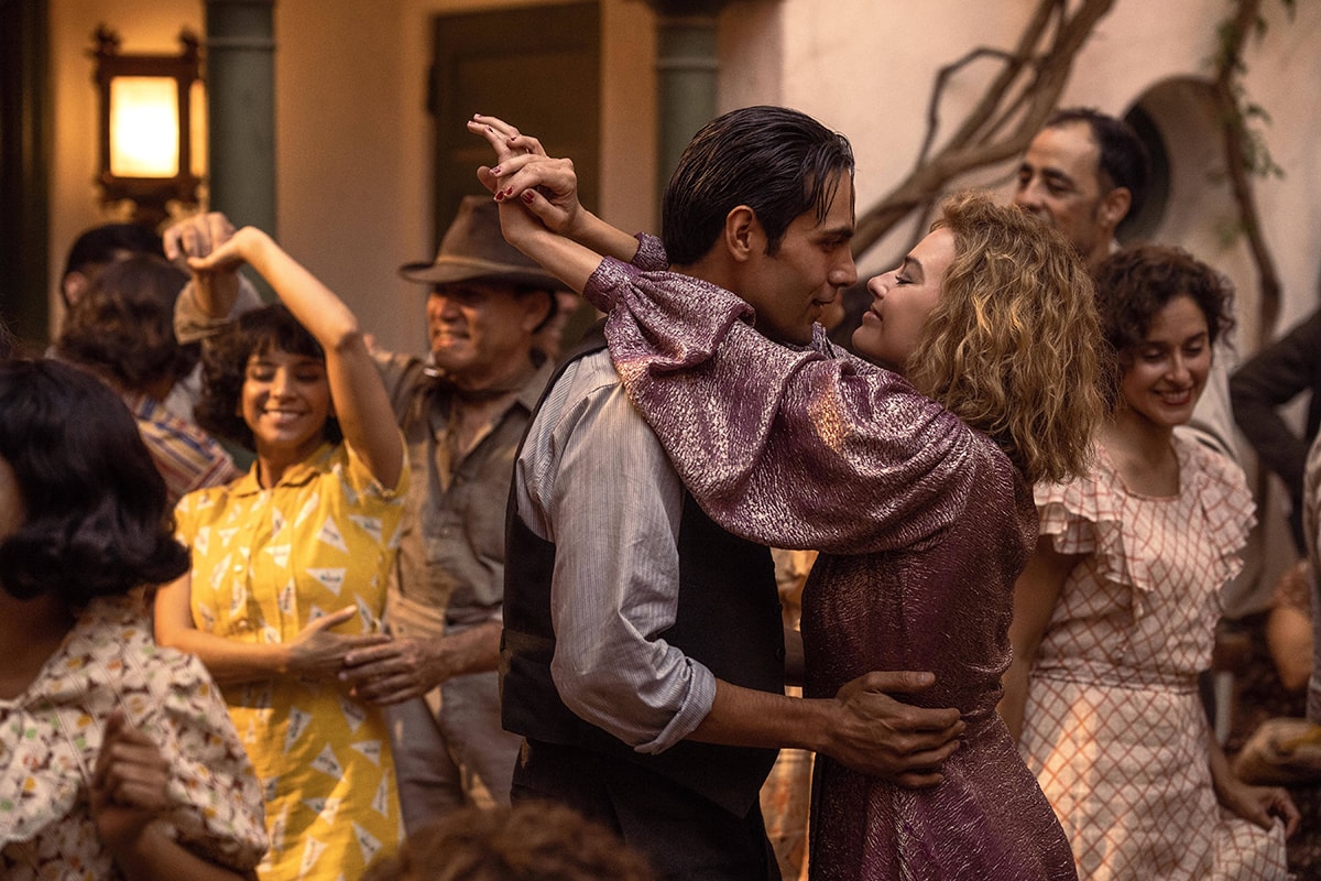 Diego Calva and Margot Robbie share a lively dance scene in Babylon, with Robbie glowing in a shimmering violet lamé puff-sleeve dress