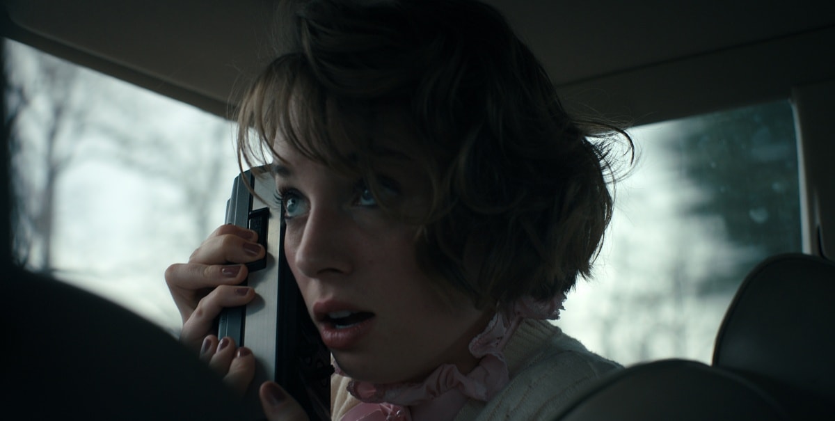 Maya Hawke as Robin Buckley in Stranger Things Season 4, caught in a tense moment while communicating over a portable radio during one of the show’s suspenseful sequences