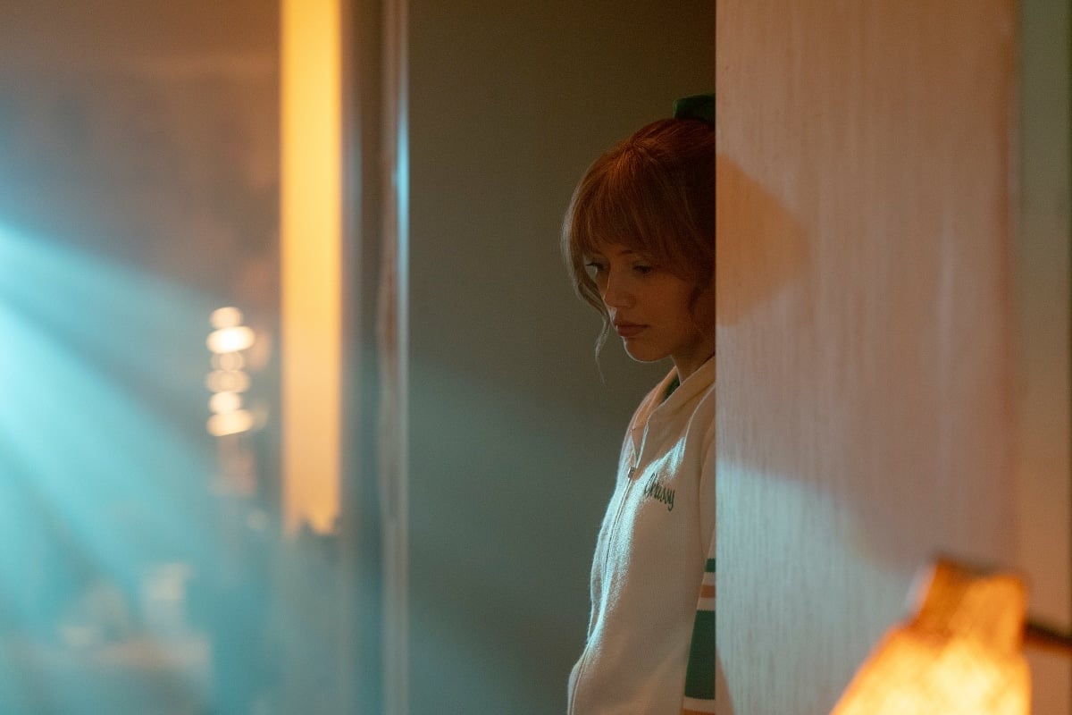 Grace Van Dien portrays a vulnerable Chrissy Cunningham in a hauntingly lit scene from Season 4 of Stranger Things, capturing the character’s inner turmoil