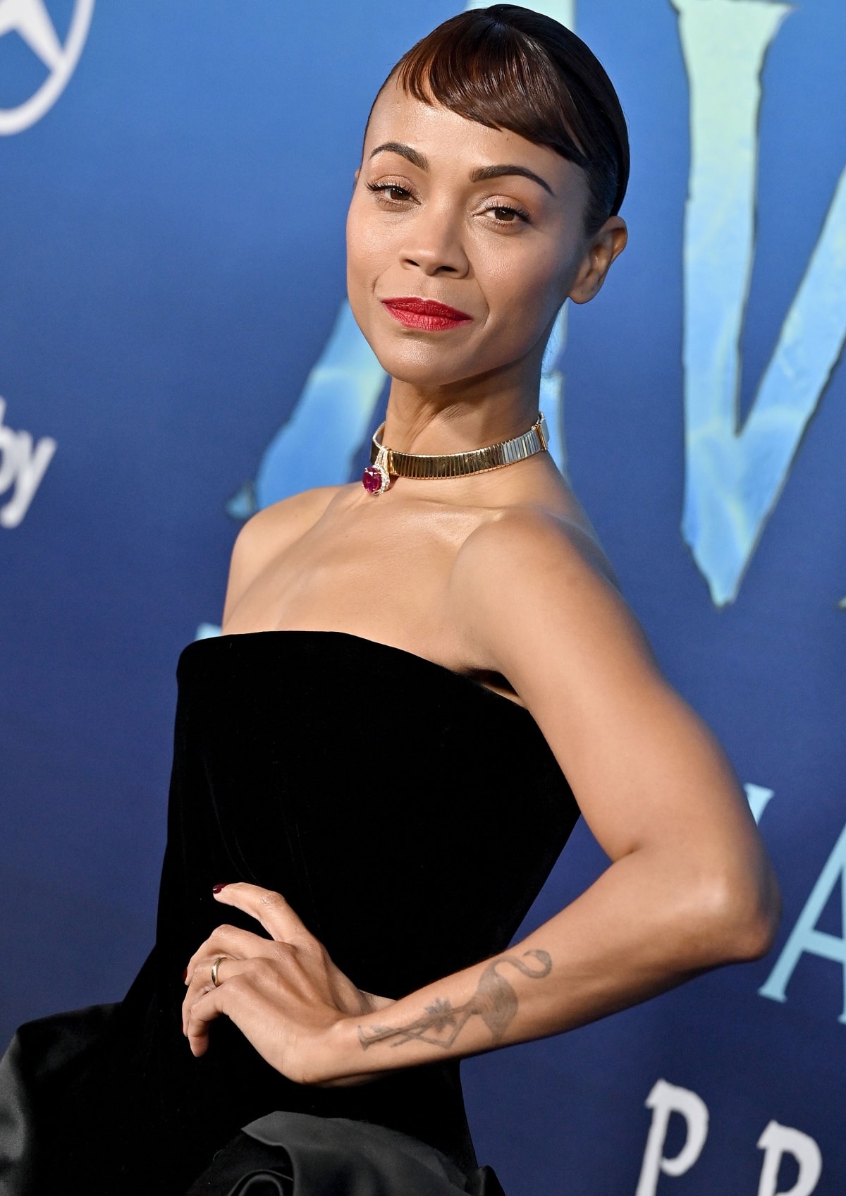 Zoe Saldaña with a side-swept fringe and a Bulgari pendant choker at the Los Angeles premiere of Avatar: The Way of Water