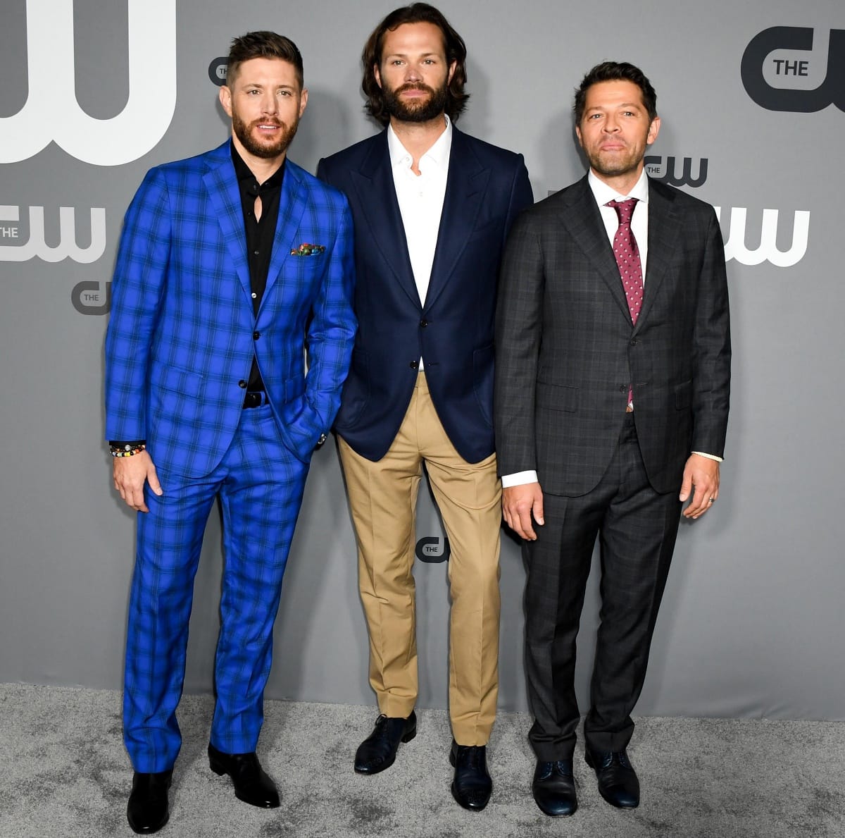 Jared Padalecki, towering at 6'4" (193 cm), made a commanding style statement at the 2019 CW Network Upfront in New York, standing between Jensen Ackles in a bold cobalt plaid suit and Misha Collins in a sleek charcoal check, while keeping it classic in a navy blazer, crisp white shirt, and tan trousers