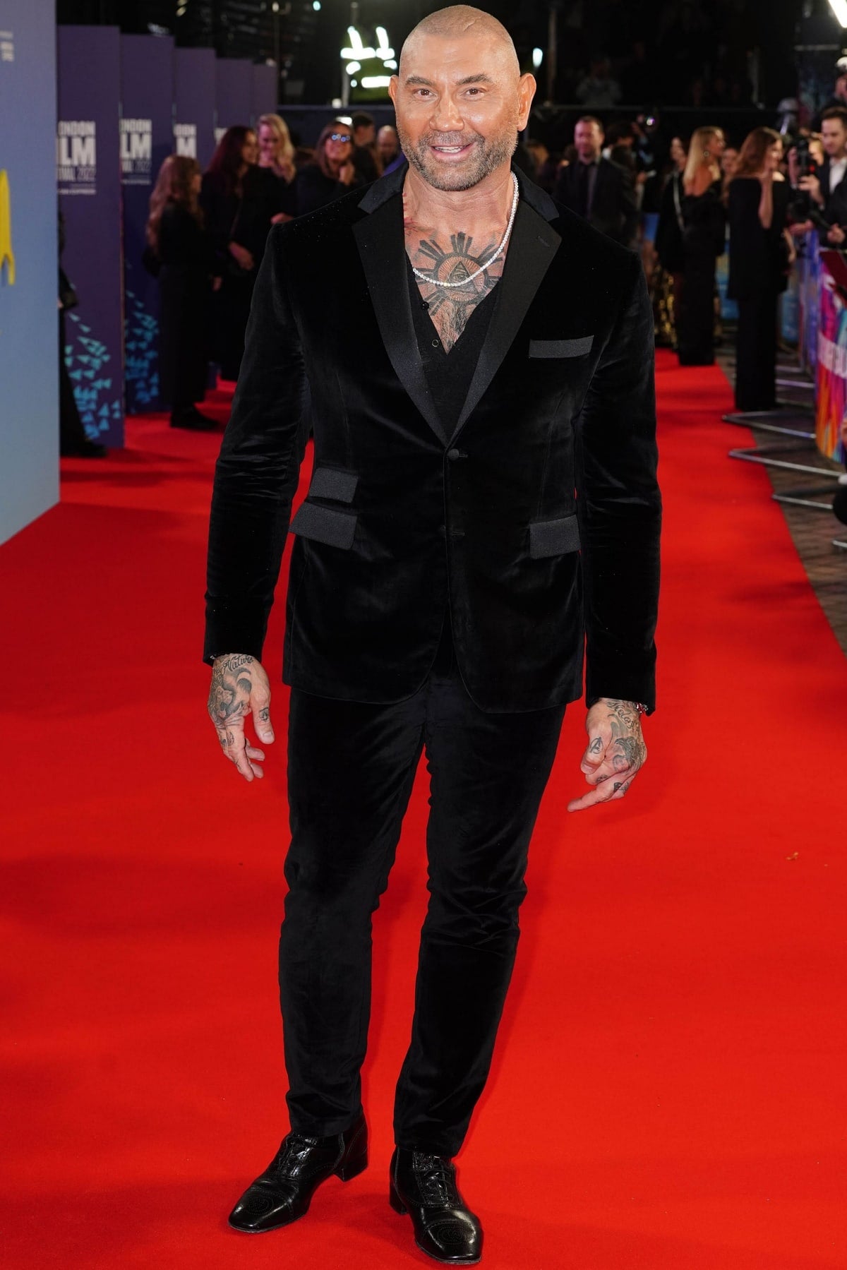 Dave Bautista, standing at 6'2 ¾" (189.9 cm), turned heads at the Glass Onion premiere during the 2022 BFI London Film Festival in a luxe black velvet suit, sleek lace-up dress shoes, and a bold peek of chest ink that elevated his red carpet presence