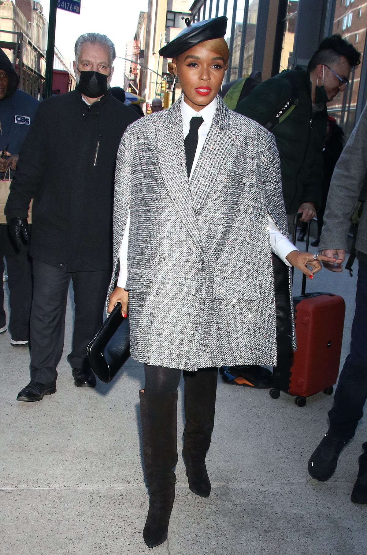 Singer and actress Janelle Monáe channeled Parisian chic in New York City, pairing a shimmering tweed blazer-style cape and leather beret with black tights and pointed-toe suede knee-high boots