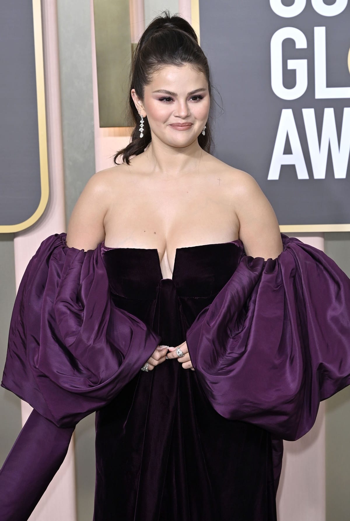 While Selena Gomez’s dress was a striking deep purple velvet, the dramatic, off-the-shoulder neckline with its plunging keyhole detail highlighted her chest