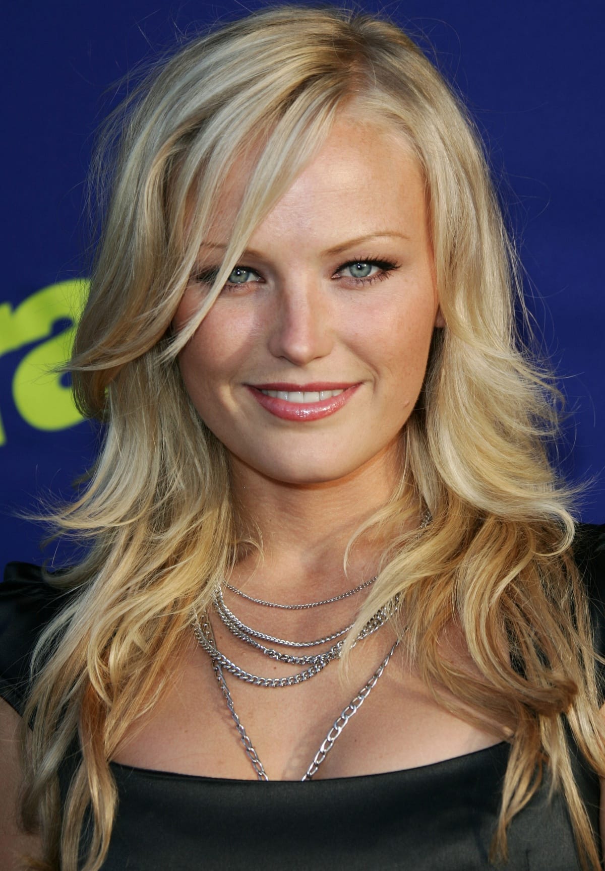 Malin Akerman stuns with her tousled blonde waves, striking blue eyes, and a layered silver chain necklace at the premiere of Entourage