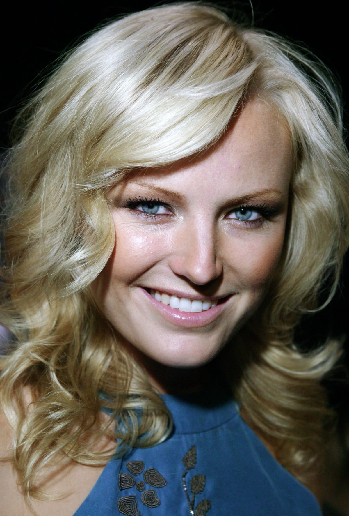 Malin Akerman captivates with her striking blue eyes and radiant smile, complemented by soft pink lips and voluminous blonde curls