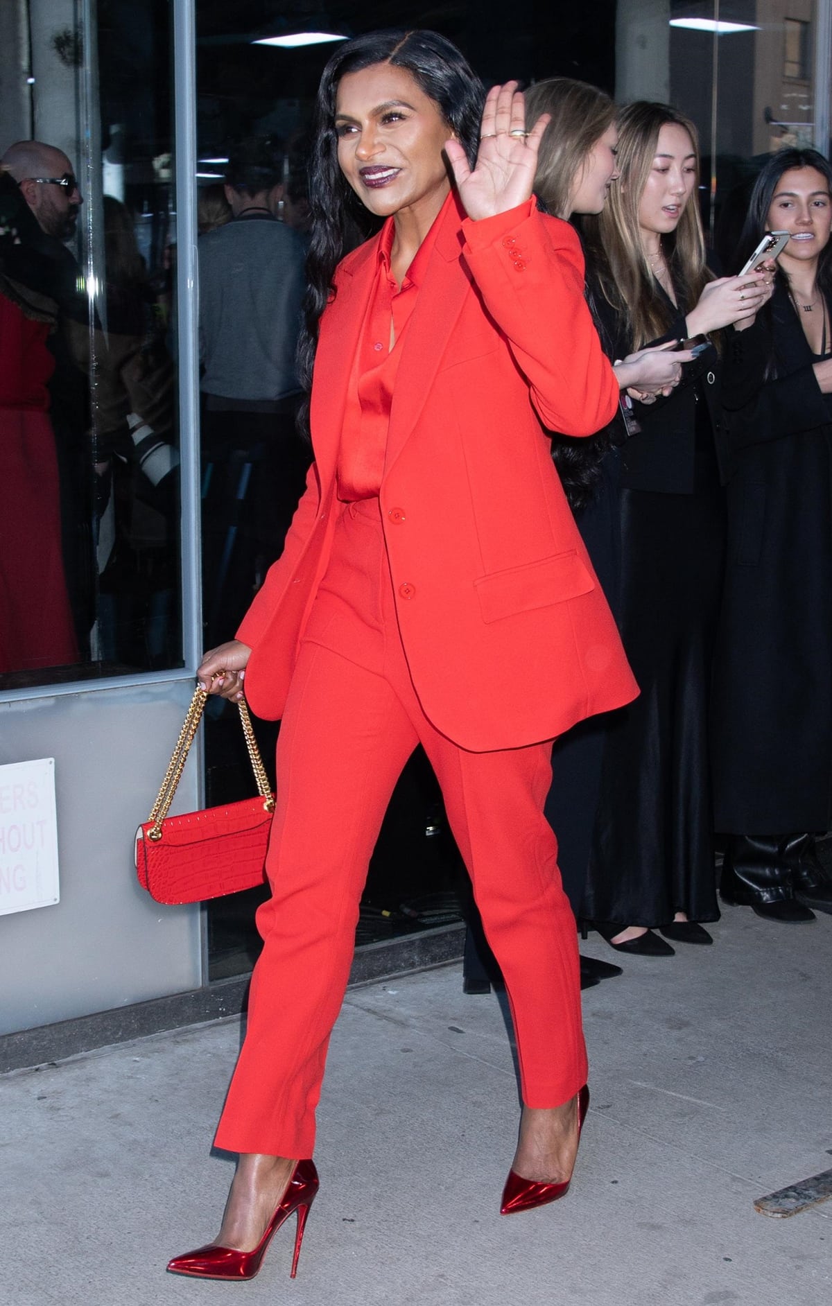 Mindy Kaling exuded confidence in a scarlet Michael Kors suit layered over a satin blouse, paired with matching Christian Louboutin “So Kate” pumps and a crocodile-embossed red handbag for a powerful monochrome statement
