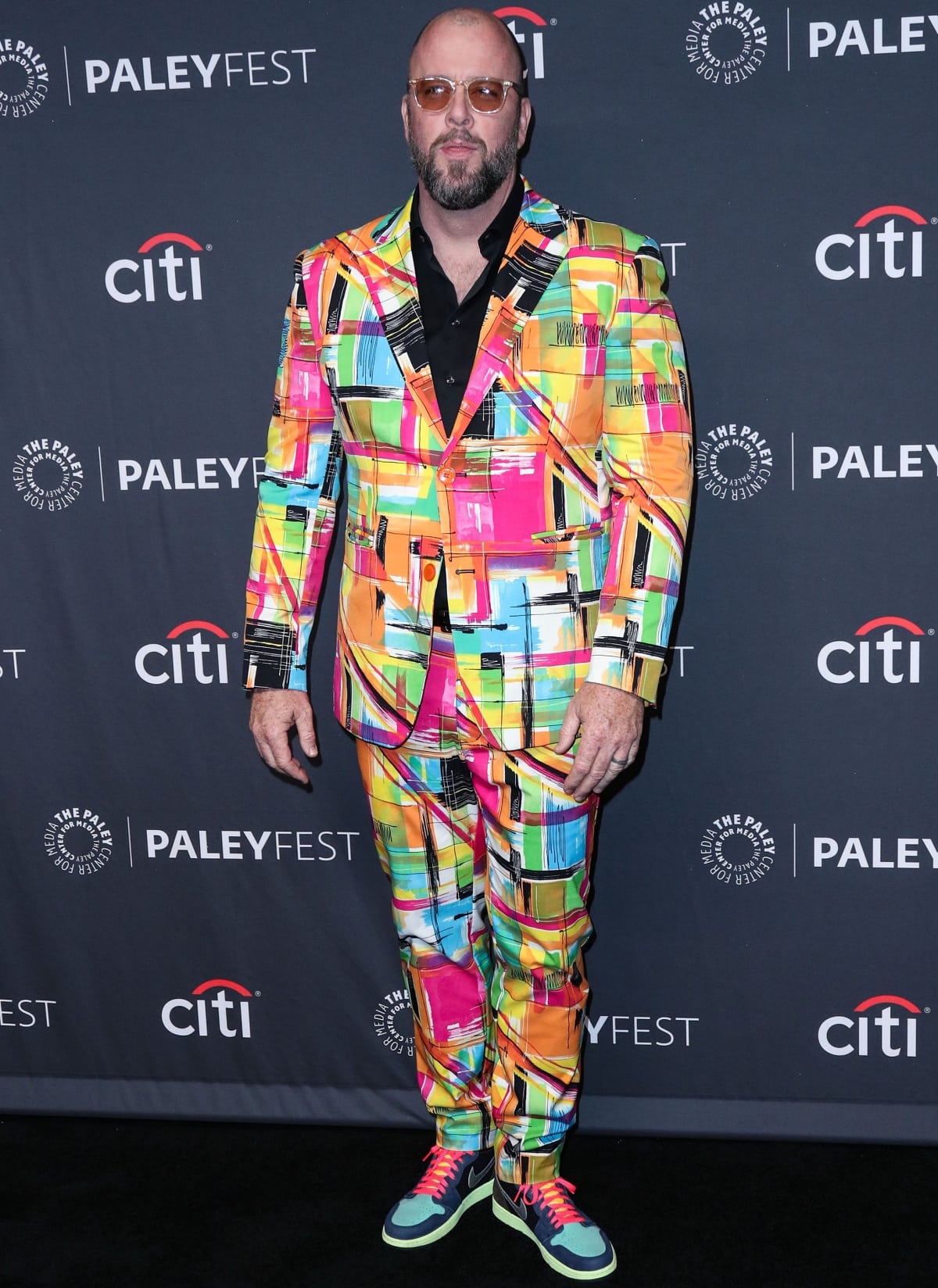 Chris Sullivan was impossible to miss at the This Is Us PaleyFest LA presentation on April 2, 2022, in Los Angeles, rocking a vibrant multicolored graffiti-print suit paired with bold neon-laced sneakers that matched his electric style