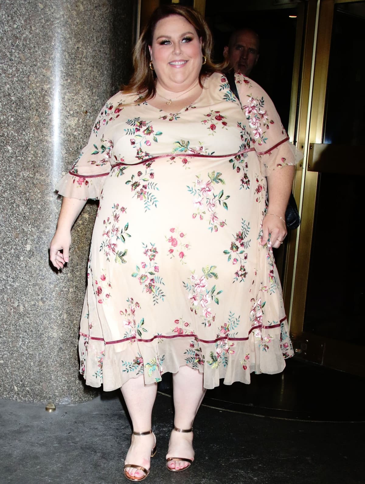 Chrissy Metz radiates confidence in a cream floral-print midi dress paired with metallic ankle-strap heels, stepping out for an appearance on New York Live in New York City on August 11, 2022