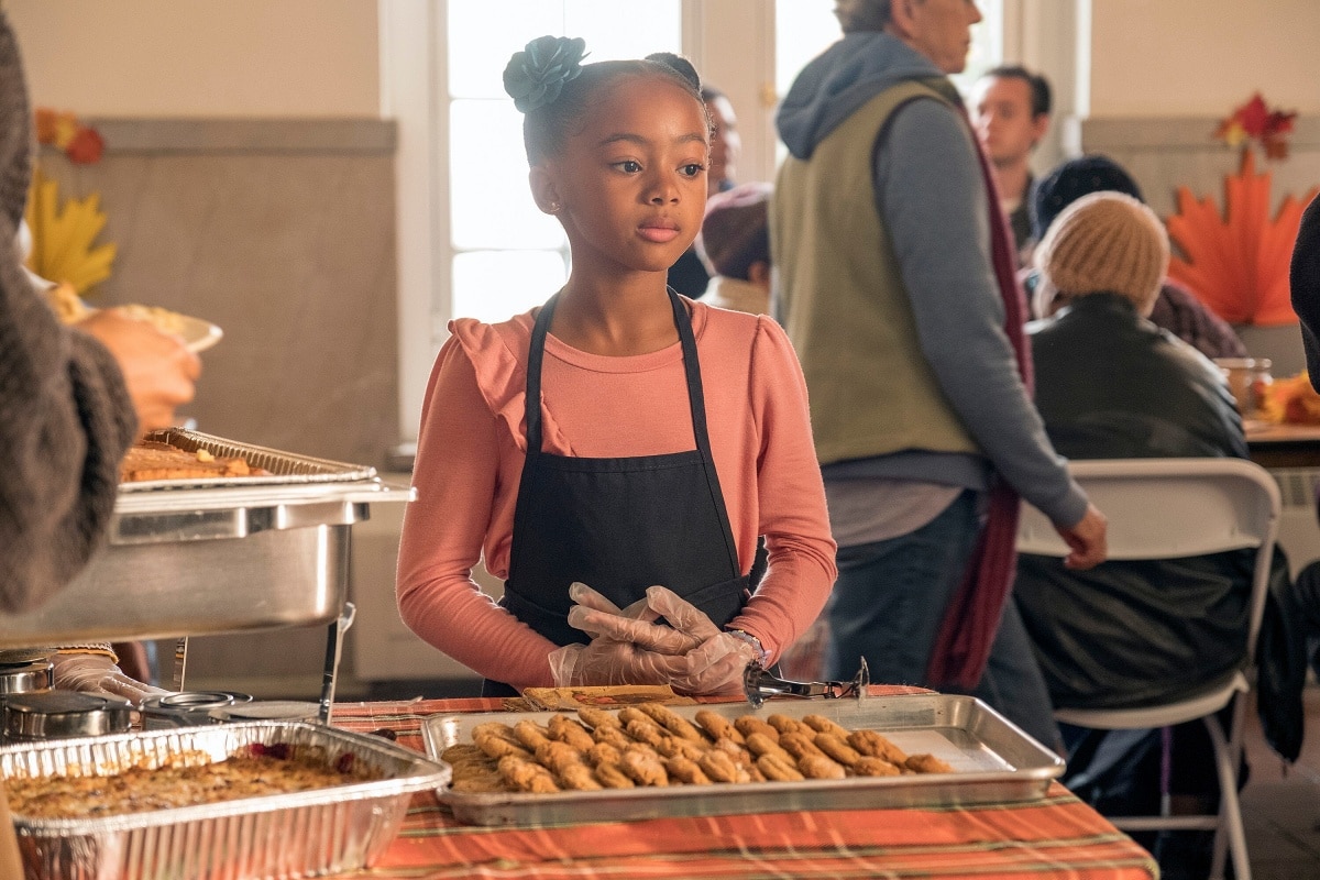 Faithe Herman as Annie Pearson, the youngest daughter of Randall and Beth, volunteers at a community event in This Is Us, showcasing her character's caring nature and strong family values