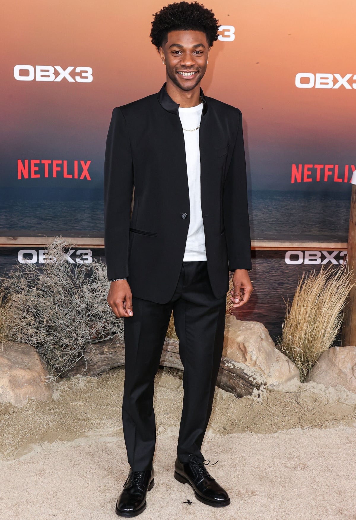 Jonathan Daviss kept it sleek and understated in a smart-casual monochromatic ensemble, pairing a tailored black suit with a white tee and polished black leather dress shoes at the premiere of Netflix’s Outer Banks Season 3