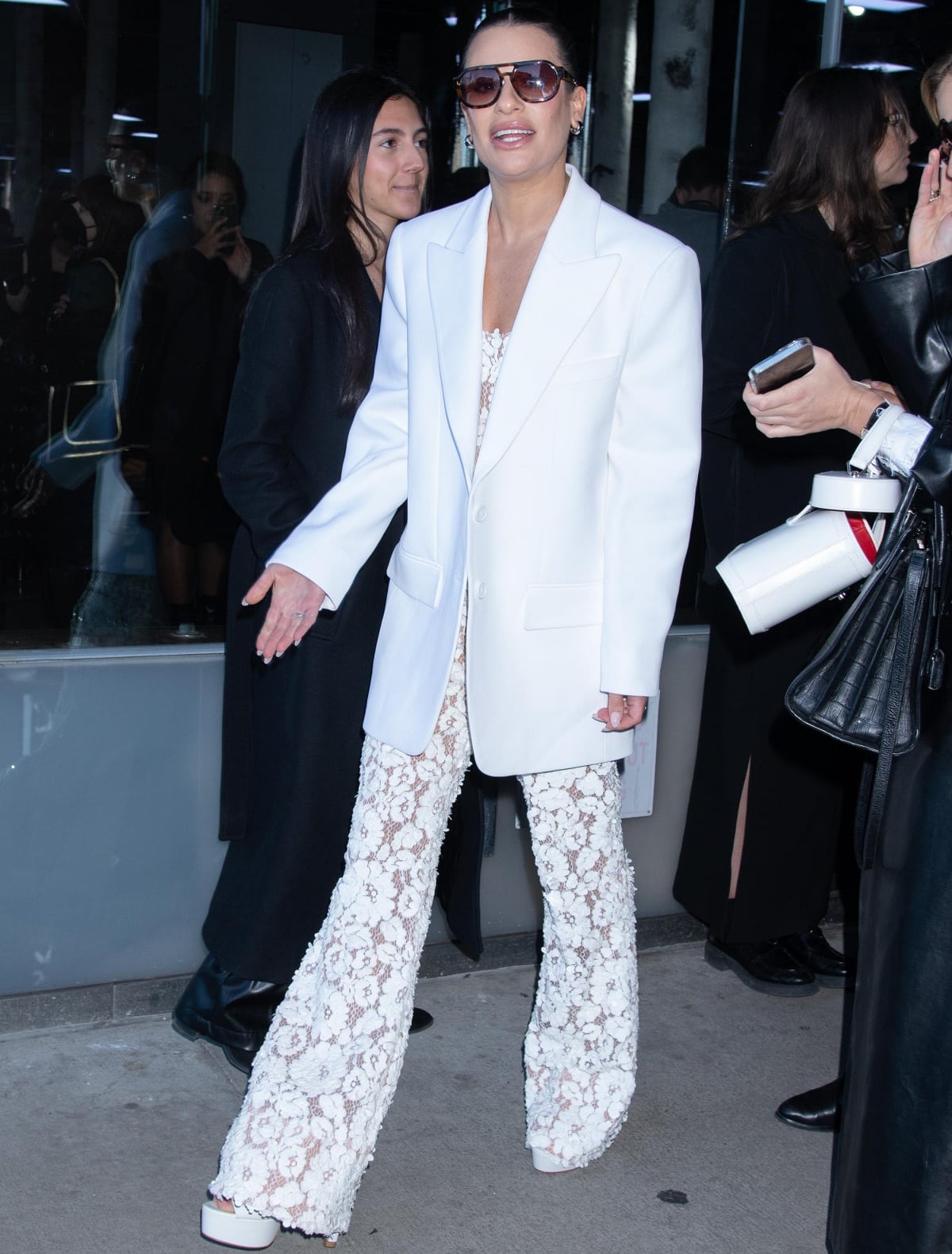 Lea Michele elevates her all-white lace ensemble with concealed platform heels, adding height and a subtle boost while maintaining the look’s clean, tailored lines