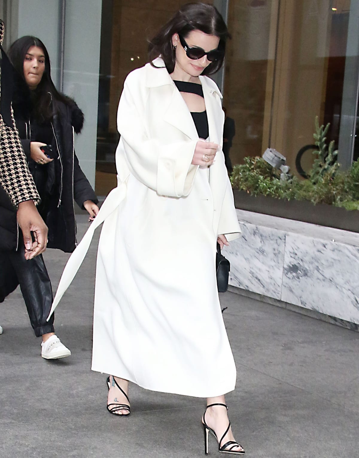 Lea Michele showcases her foot tattoos in strappy Jimmy Choo Tesca sandals, their delicate lines and slim stiletto heel adding a refined, barely-there finish to her sleek monochrome look