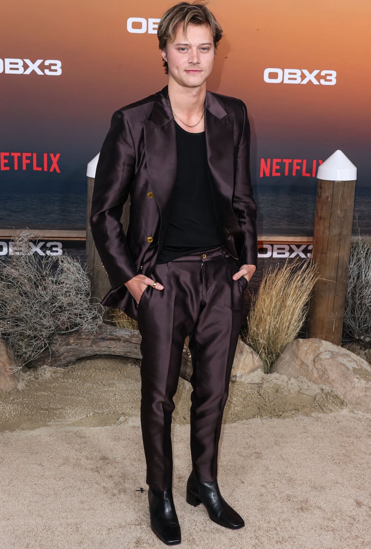Rudy Pankow, who wears a US men’s size 11 shoe, brought modern polish to classic tailoring in a rich brown Dolce Gabbana Mikado silk Sicilia-fit suit, pairing the sleek look with sharp square-toe black leather boots at the premiere of Netflix’s Outer Banks Season 3