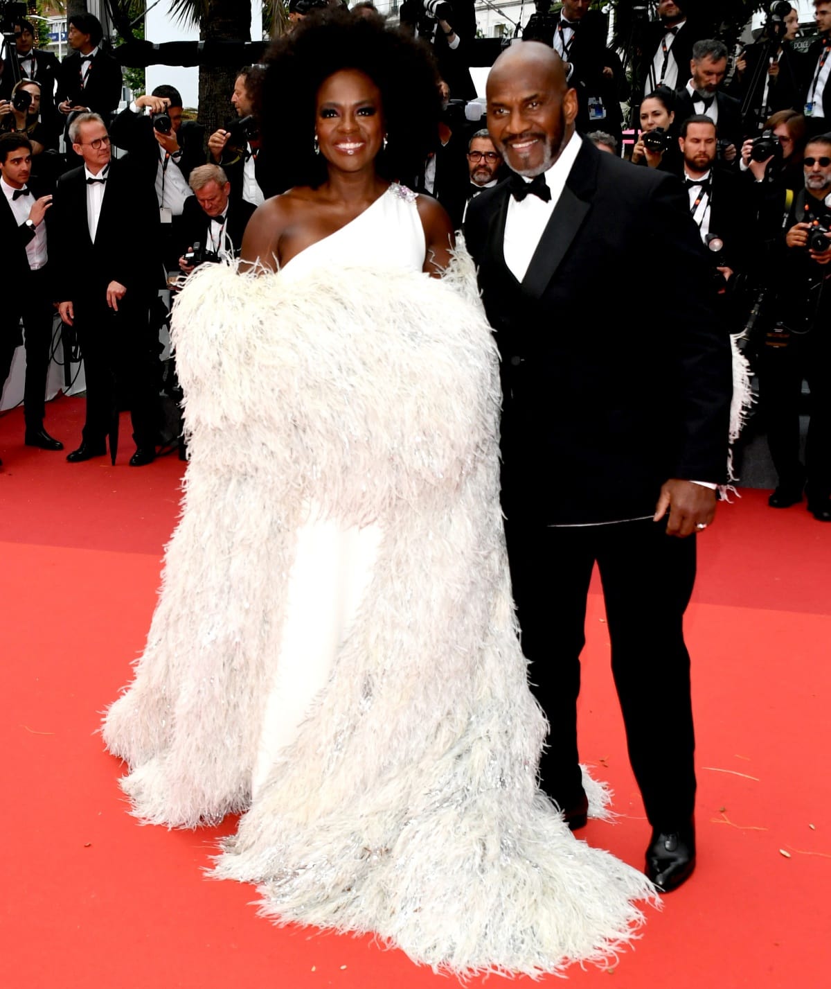 At the premiere of Monster during the 76th Cannes Film Festival on May 17, 2023, Viola Davis wore a custom white one-shoulder Valentino Haute Couture gown with a voluminous feathered coat, styled with Chopard jewelry, Valentino platform shoes, and satin heels, while her husband Julius Tennon complemented her in a classic black double-breasted tuxedo