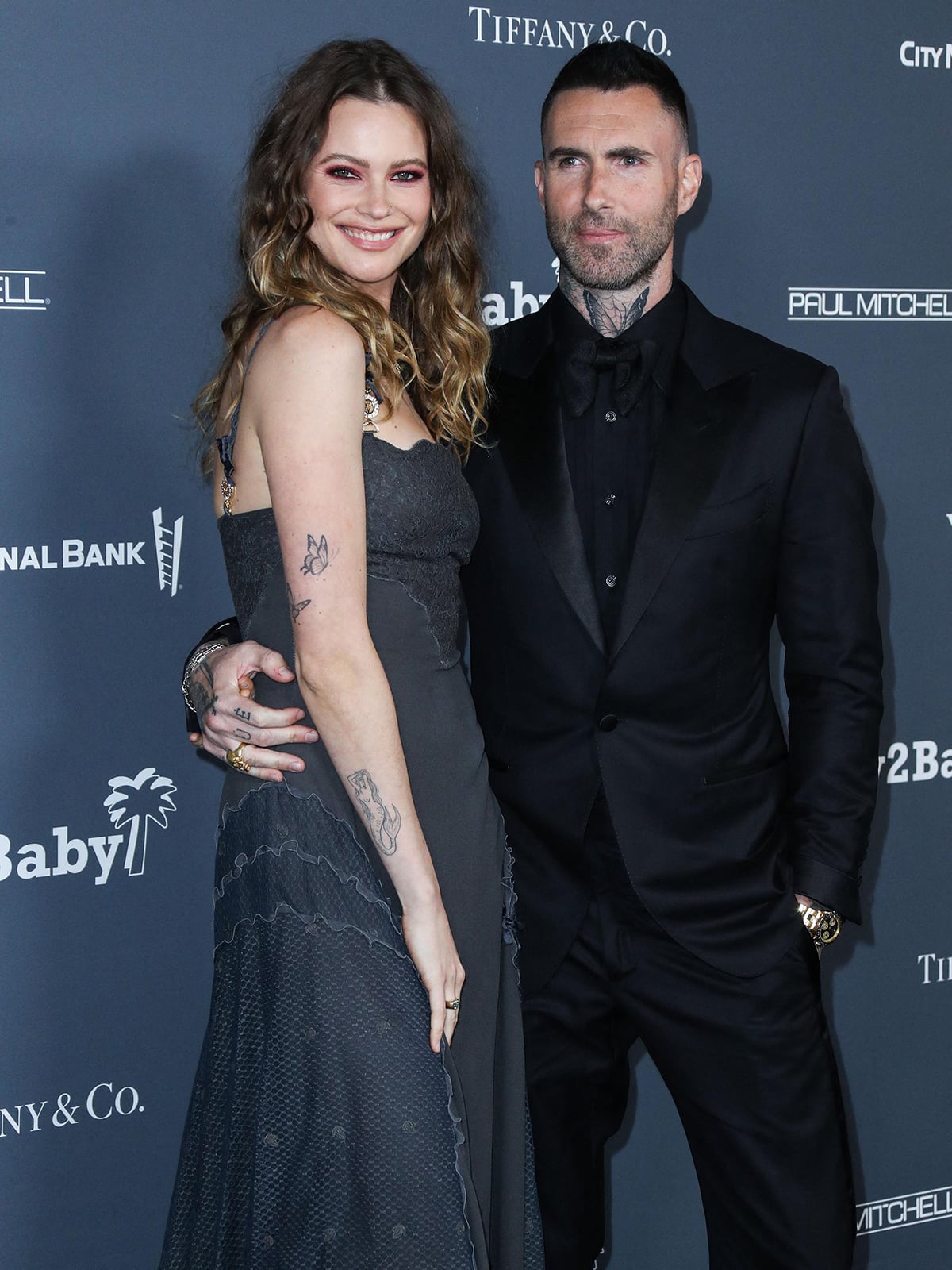 Behati Prinsloo glows in a romantic strapless gray gown while Adam Levine keeps it classic in an all-black tux at the Baby2Baby Gala
