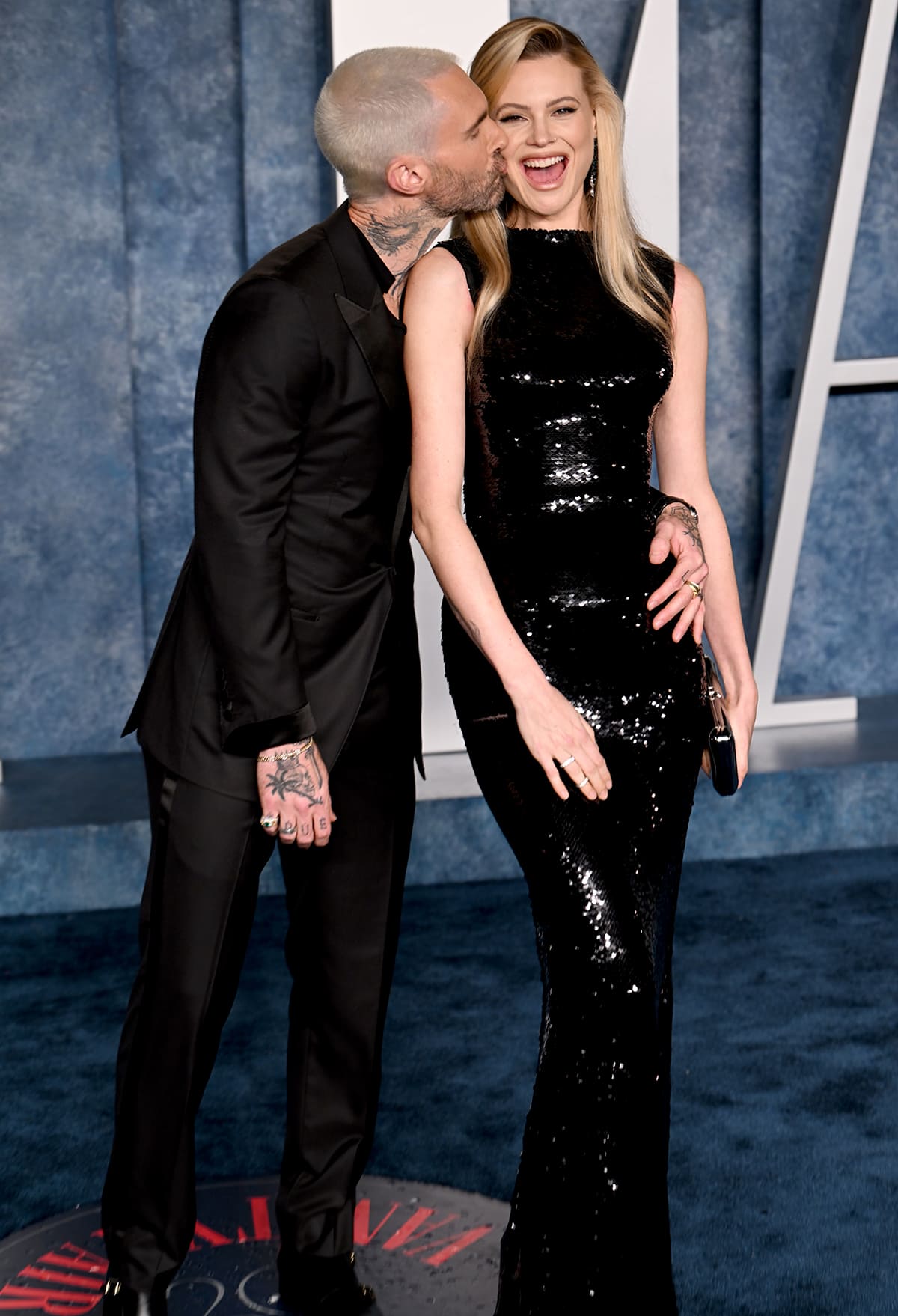 Adam Levine and Behati Prinsloo coordinate in sleek all-black looks at the 2023 Vanity Fair Oscar After-Party, with Behati dazzling in a sequin Dolce Gabbana gown and Adam in a sharp tuxedo