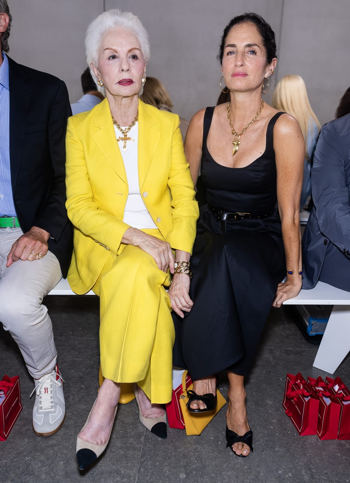 Fashion designer Carolina Herrera, radiant in a bold yellow pantsuit, sits front row with her daughter Carolina Adriana Herrera at the Carolina Herrera Spring/Summer 2024 Ready-to-Wear show during New York Fashion Week on September 12, 2023, in New York City