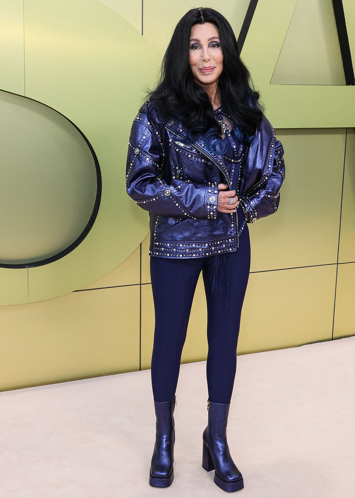 Cher flaunts her slim figure in a blue jumpsuit with a metallic blue studded jacket and matching platform boots