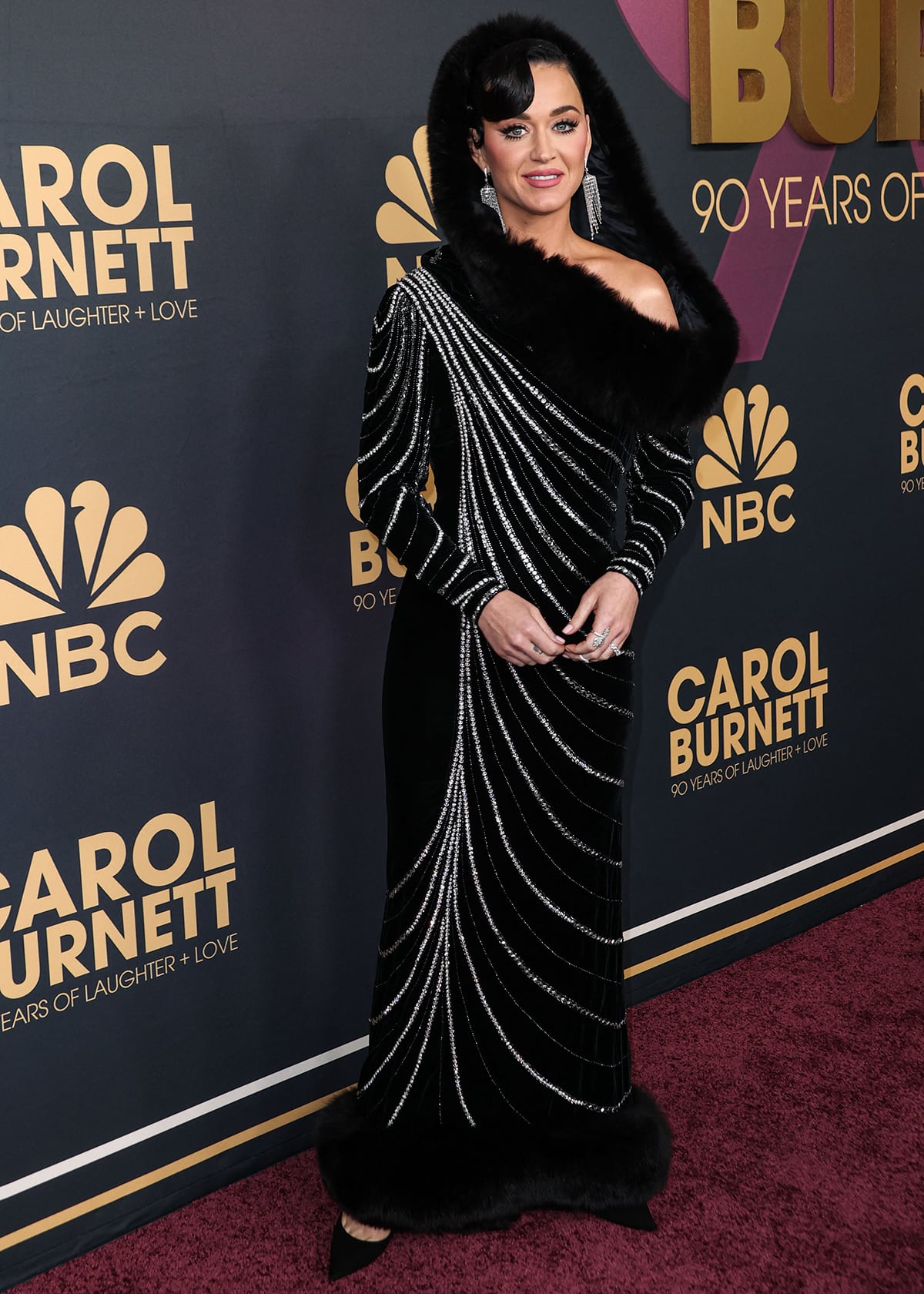 Katy Perry exudes vintage glamour in a black Bob Mackie hooded gown with crystal embellishments and fur trim, paired with classic pointed-toe pumps at NBC's Carol Burnett: 90 Years of Laughter + Love special