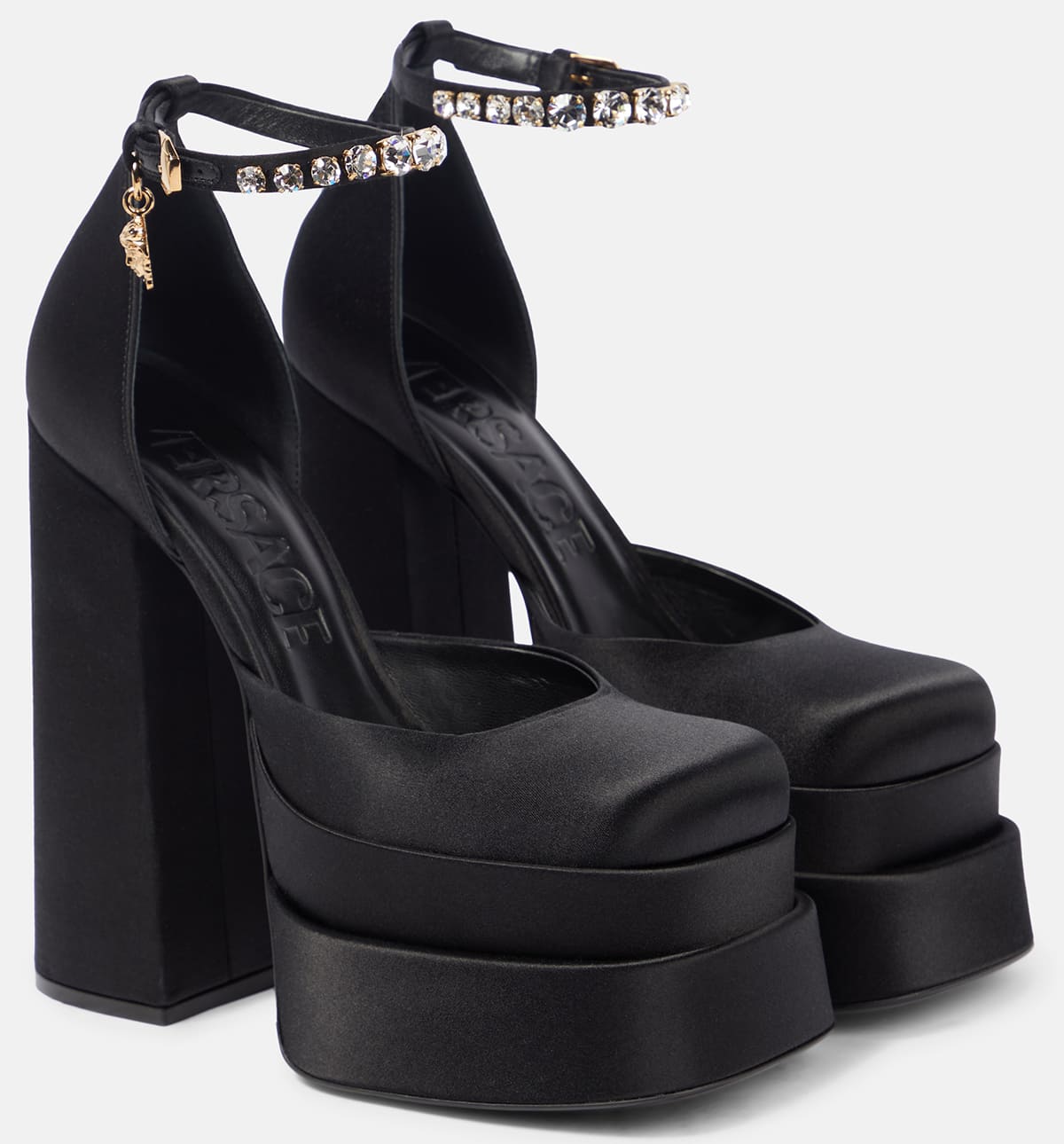 The Medusa Aevitas platform pumps are characterized by chunky double platforms, crystal-encrusted ankle straps, and block heels