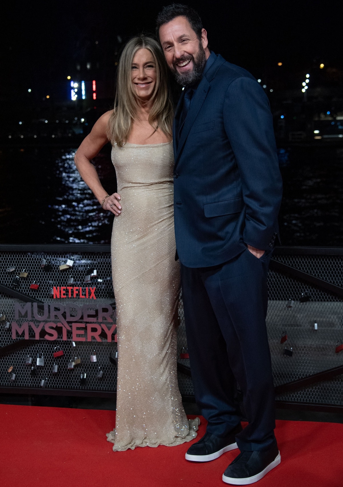 Jennifer Aniston dazzles in a shimmering gold gown while Adam Sandler opts for a relaxed navy suit with sneakers at the Murder Mystery 2 red carpet premiere