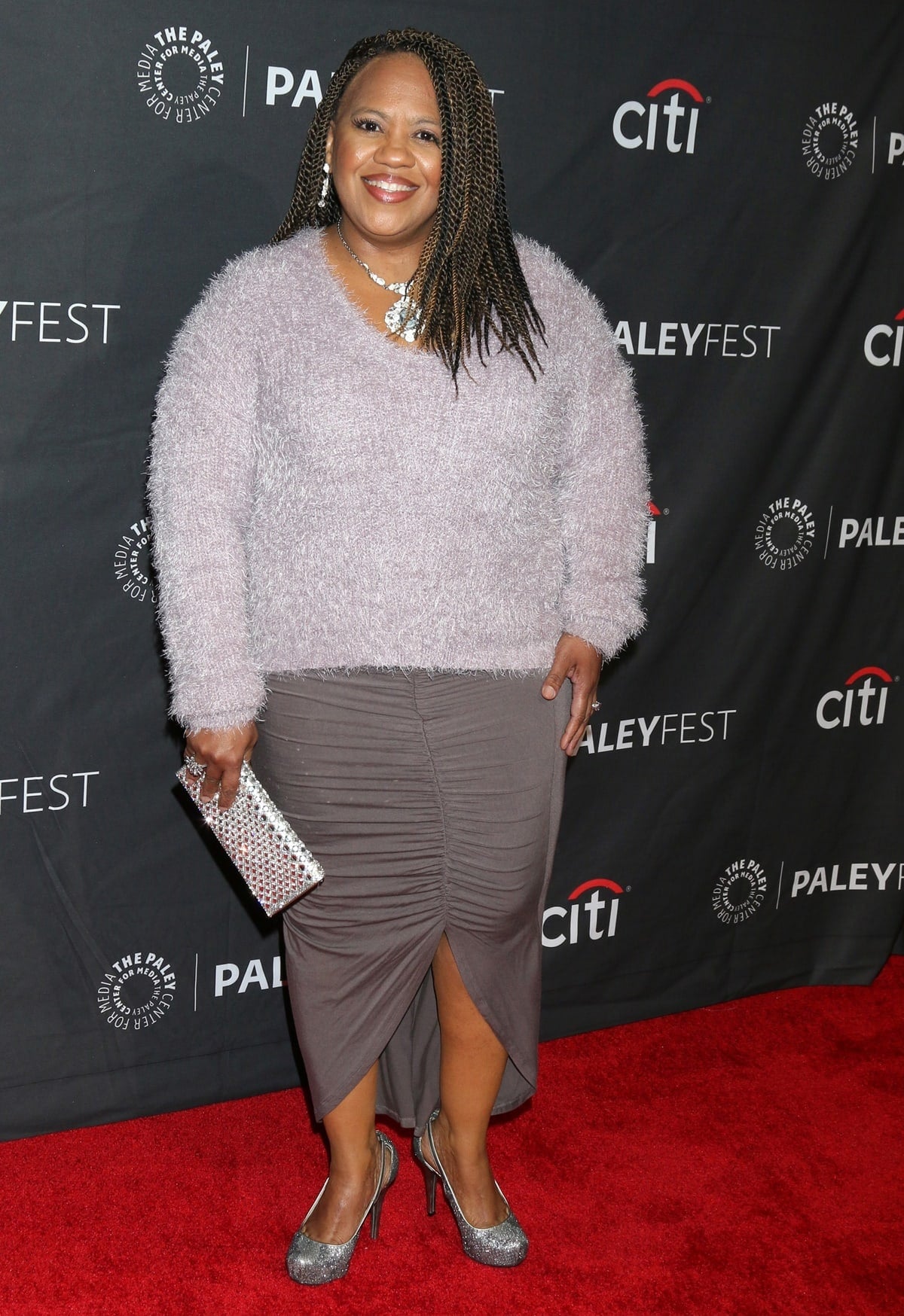 Chandra Wilson sparkled at PaleyFest LA in a soft lavender fuzzy sweater, ruched gray skirt, and silver glitter platform heels paired with a matching embellished clutch