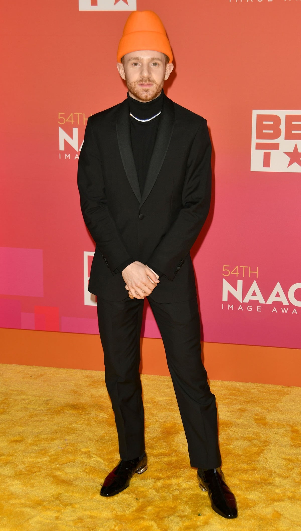 Chris Perfetti makes a bold style statement in a sharp Richard James suit, black Paul Smith turtleneck, and glossy Christian Louboutin heels at the 54th annual NAACP Image Awards, held February 25, 2023, at the Pasadena Civic Auditorium in Pasadena, California