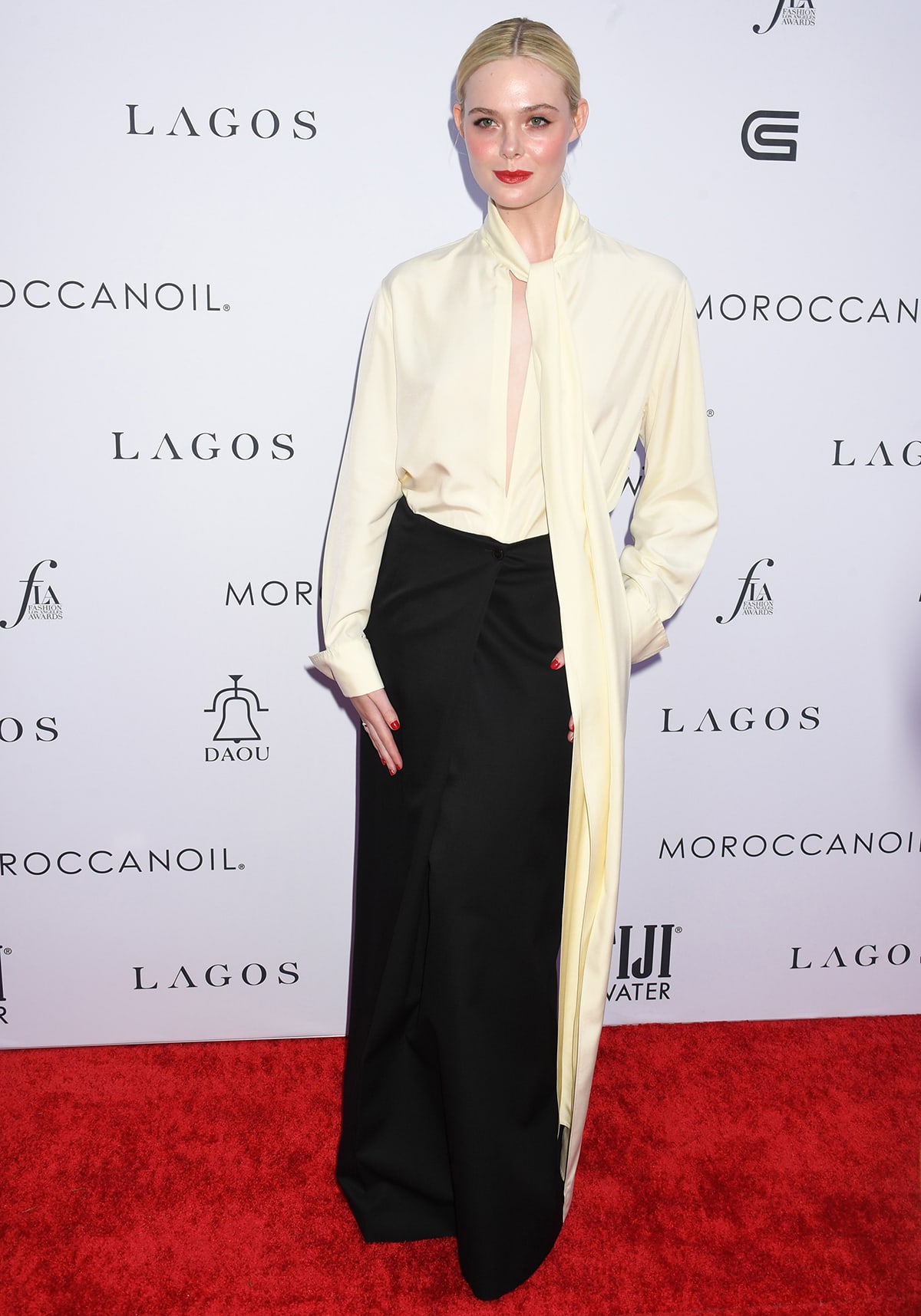 Elle Fanning delivers modern “girl boss” polish in a cream pussy-bow blouse and black Givenchy maxi skirt, anchoring the minimalist red-carpet look with classic heels at Daily Front Row’s 7th Annual Fashion Los Angeles Awards on April 23, 2023