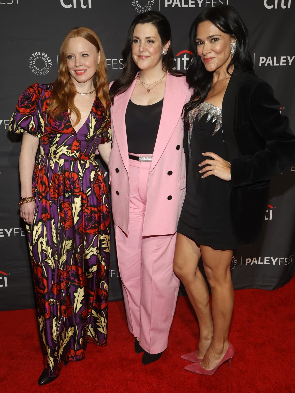 Lauren Ambrose brightens the carpet in a vivid floral gown and pointed black heels, Melanie Lynskey opts for a pastel pink power suit with black pumps, and Simone Kessell adds an edge in a black velvet blazer and pink suede stilettos at PaleyFest LA 2023