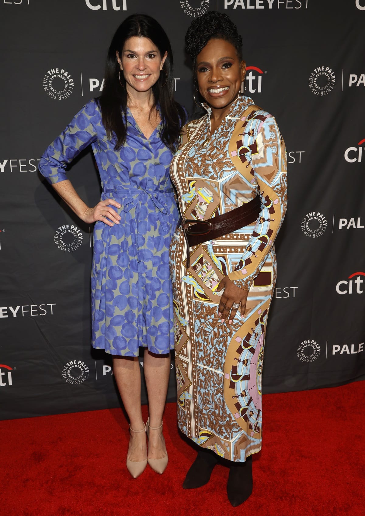 Maureen J. Reidy, in a cobalt blue wrap dress and nude pointed-toe heels, appears taller than Sheryl Lee Ralph, who stuns in a vibrant geometric print dress and sleek black boots at the 2023 PaleyFest LA