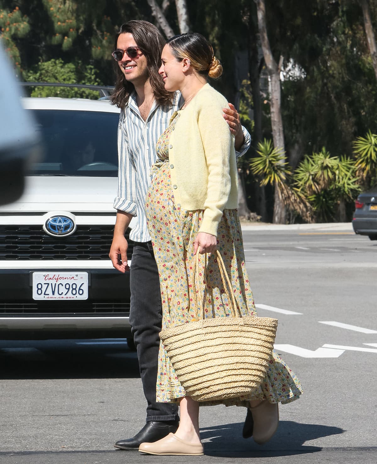 Pregnant Rumer Willis, hand-in-hand with Derek Richard Thomas, showcases her growing baby bump in a charming yellow floral maternity maxi dress and a matching yellow cardigan while out in West Hollywood on April 10, 2023